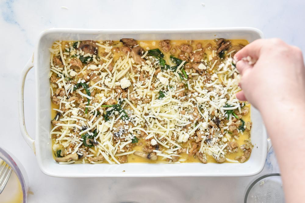 assembling the breakfast casserole before baking in the oven.