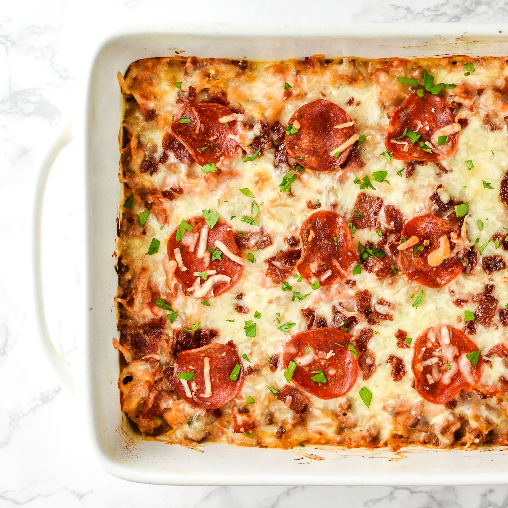 Mouth-watering top view of Meat Lover's Spaghetti Squash Pizza Casserole - It's pizza, but morphed into a not-that-bad-for-you spaghetti squash casserole with meat lover's toppings! - pmp.local