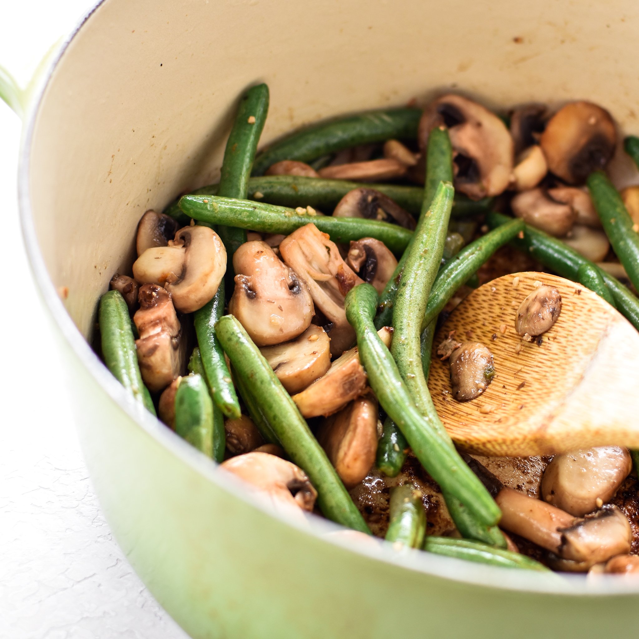 Mushrooms and green beans cooking the Dutch Oven. This One-Pot Pesto Chicken and Rice is the perfect idea if you're short on dinner prep time. - pmp.local