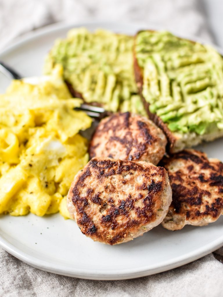ground turkey breakfast patties with eggs and avocado toast.