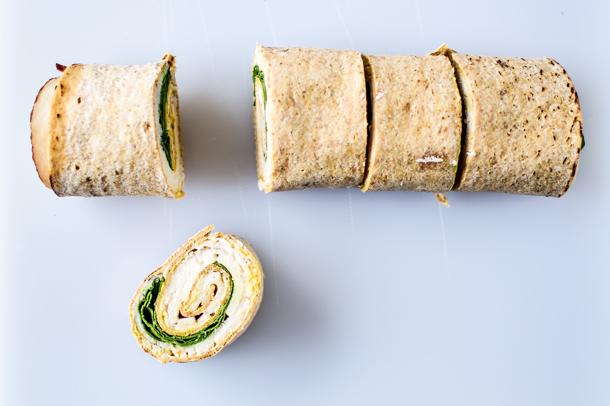 A turkey pinwheel that was just cut up with one pinwheel pulled out and face up.