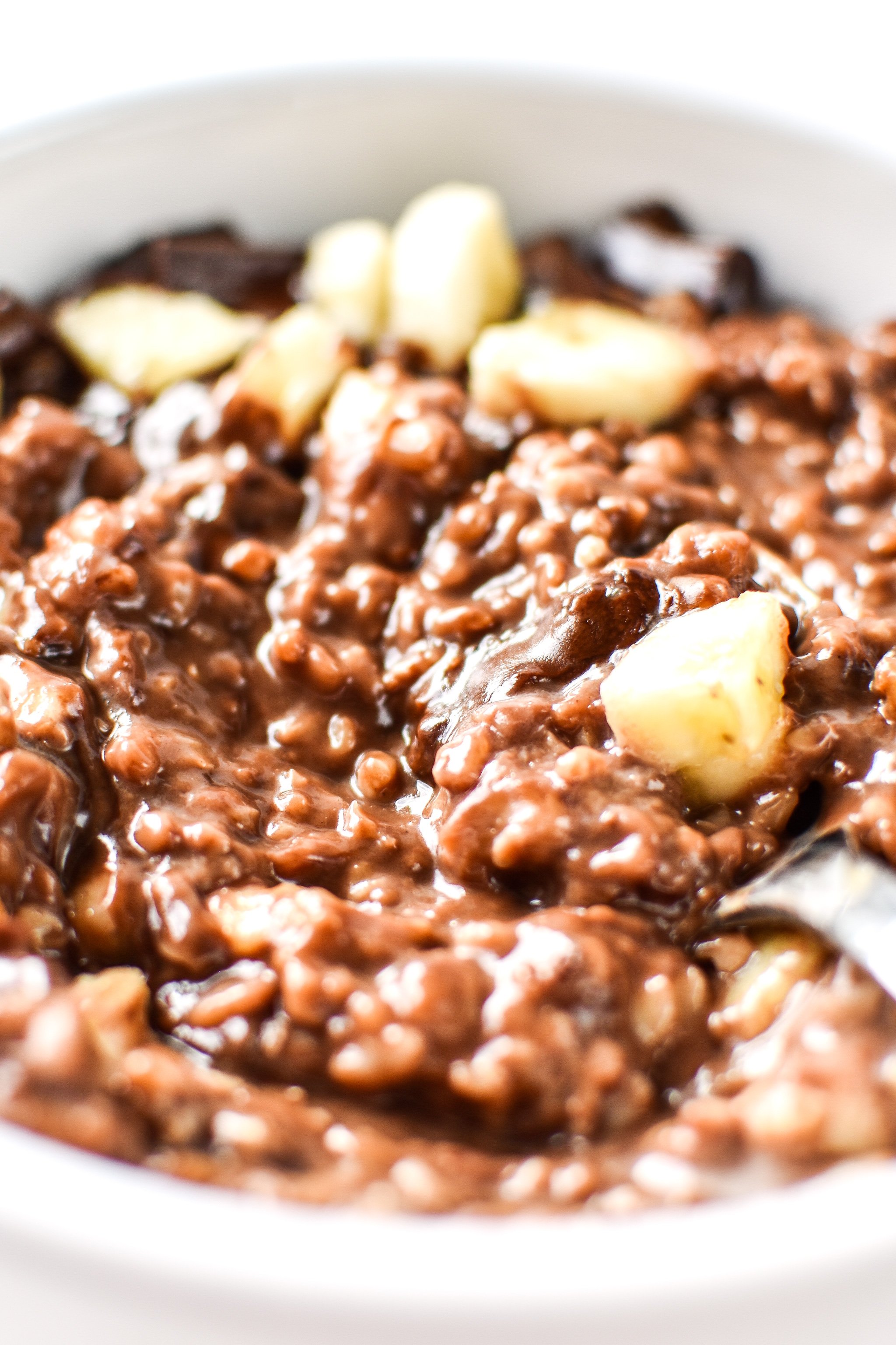 taking a spoonful from the bowl of chocolate banana steel cut oats