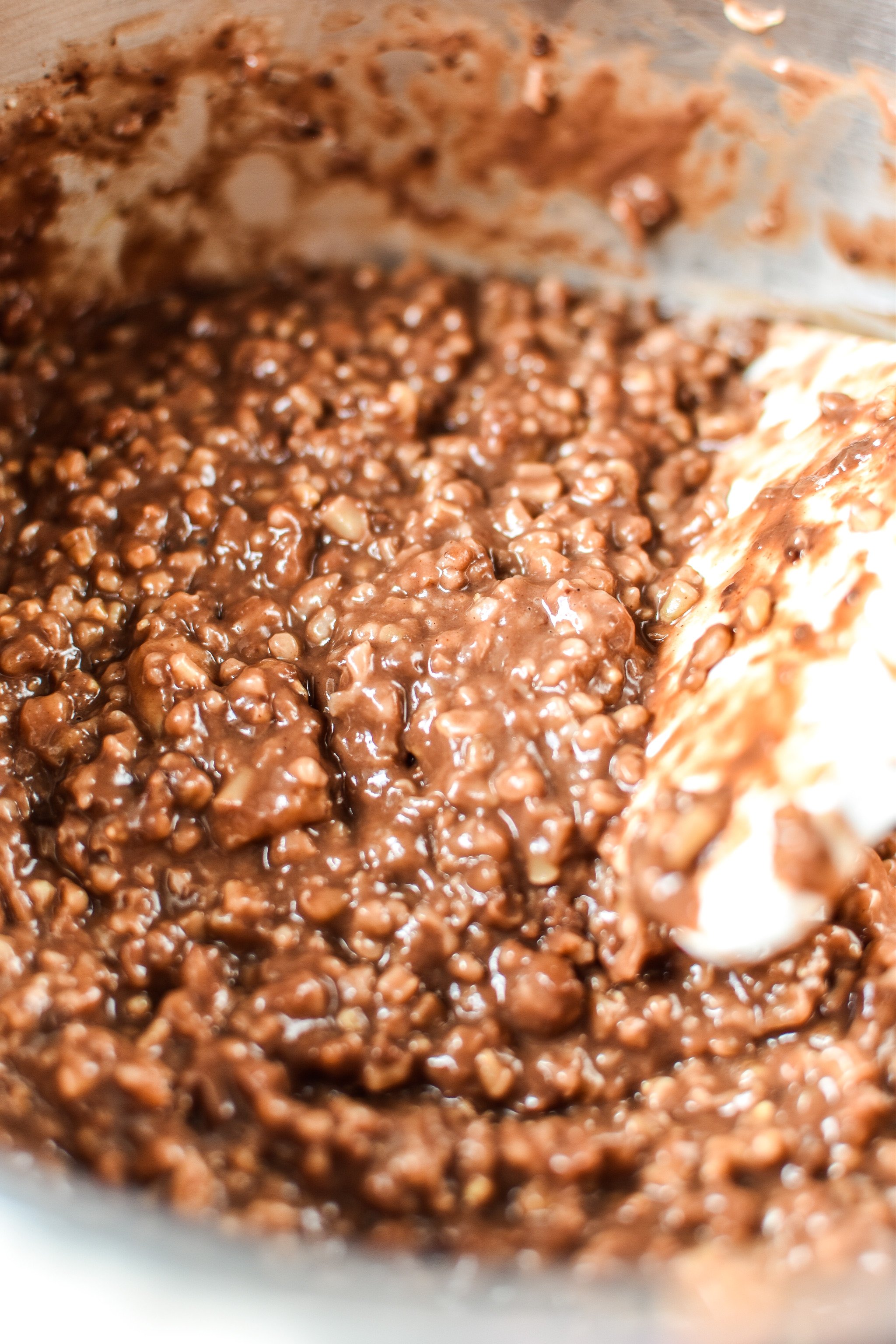 Chocolate banana steel cut oats being cooked on the stove top with the cocoa powder added.