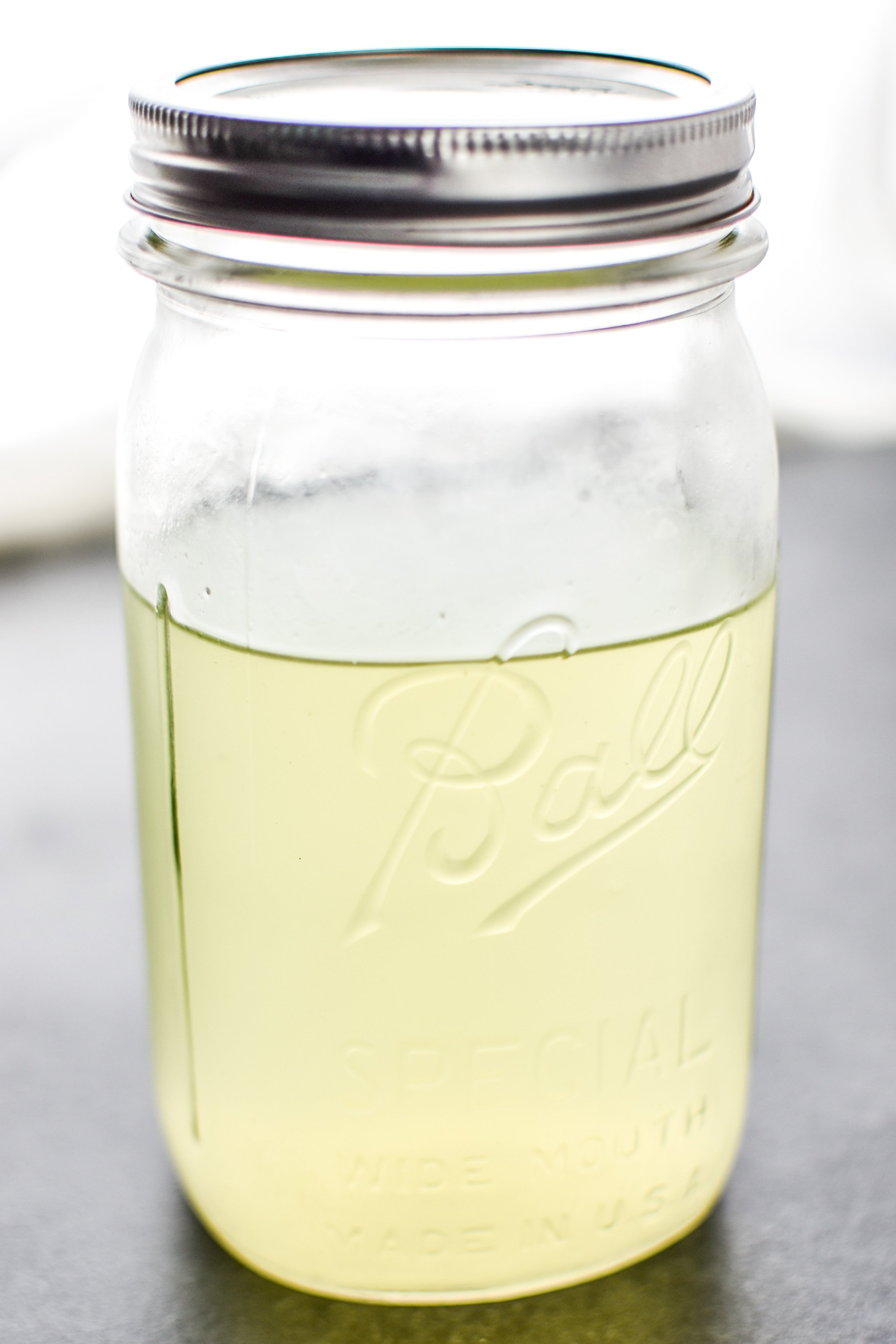 A jar full of leftover whey that has drained off yogurt to create Greek yogurt.