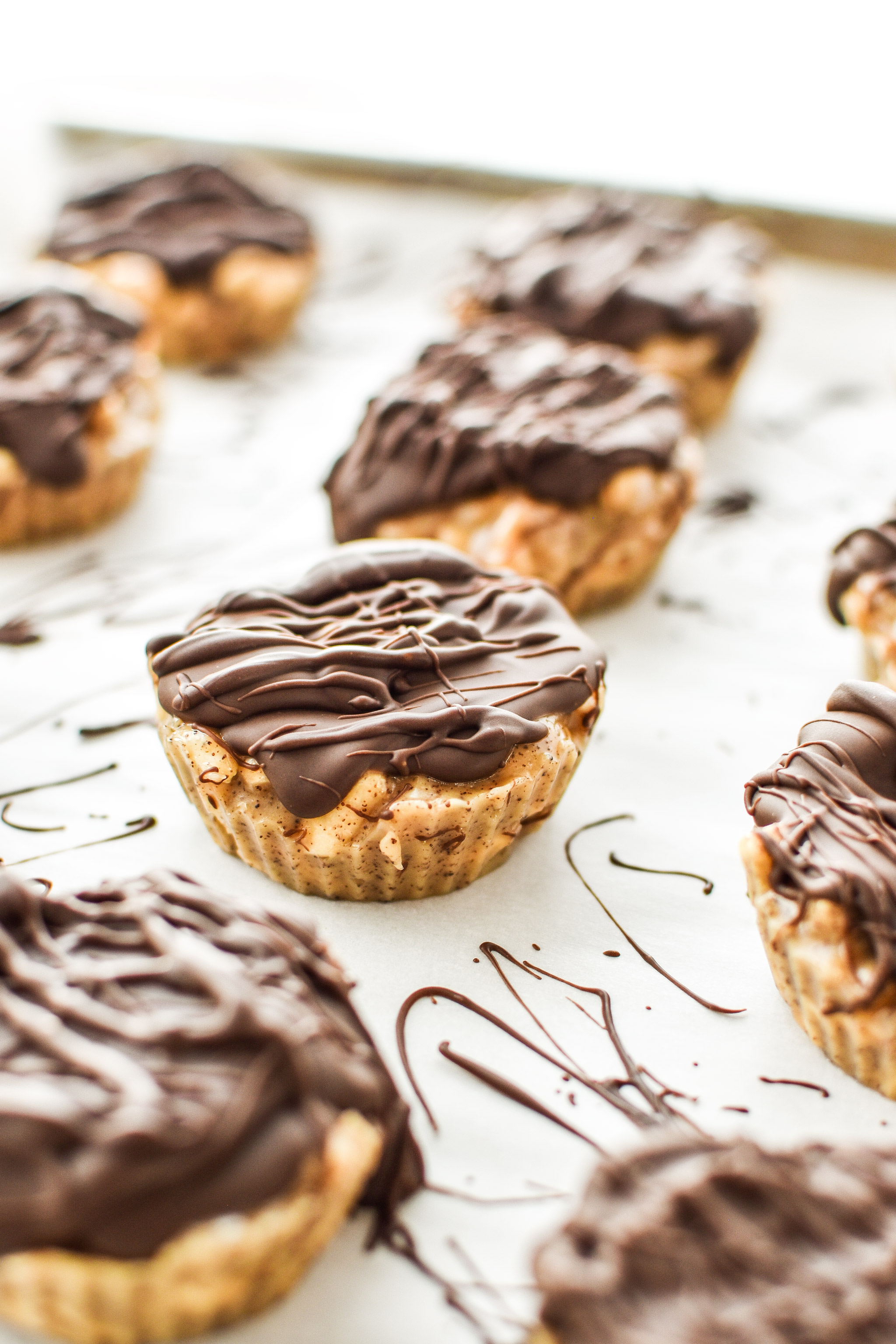 espresso crunch cashew butter cups with chocolate drizzle on top.