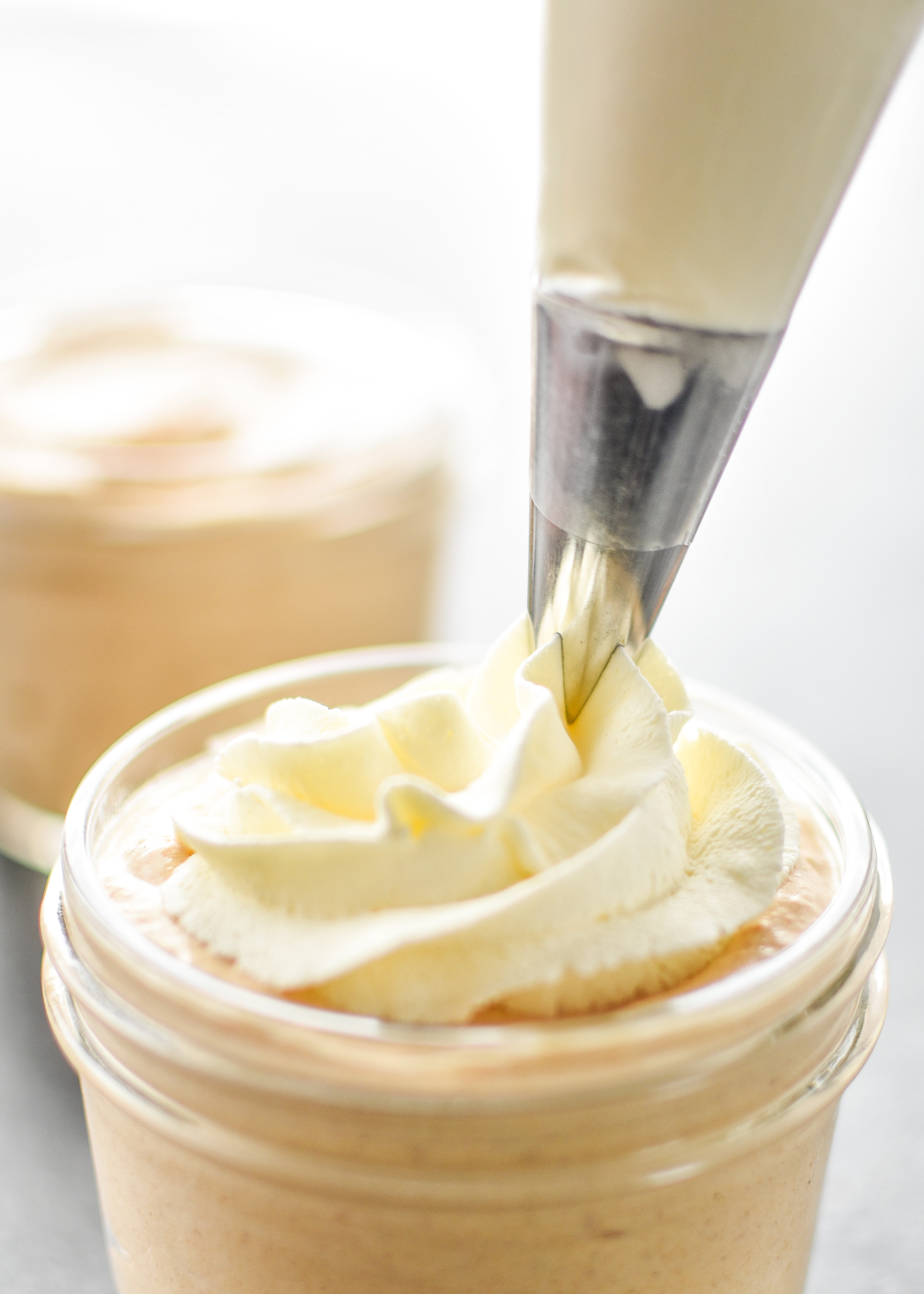 Piping whipped cream on the pumpkin spice whipped greek yogurt.