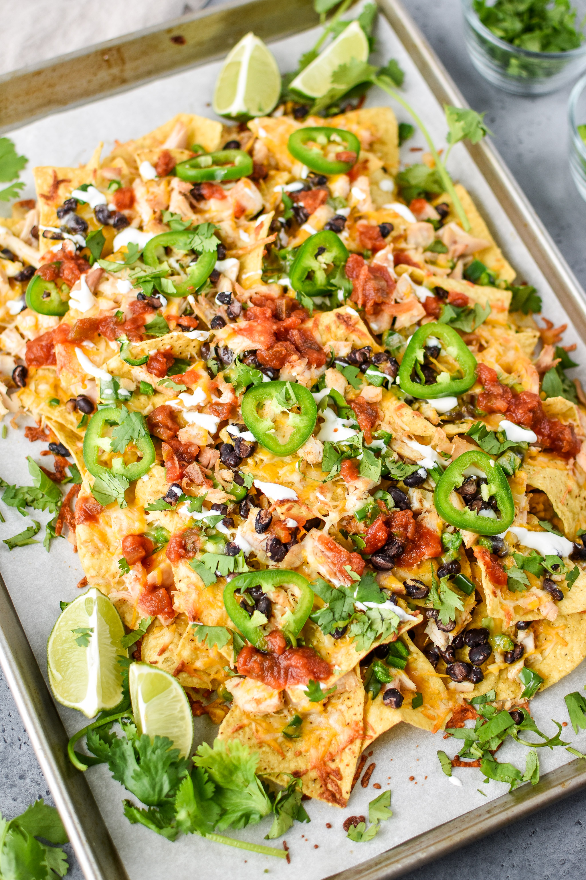 A sheet pan of prep ahead rotisserie chicken nachos fresh from the oven.