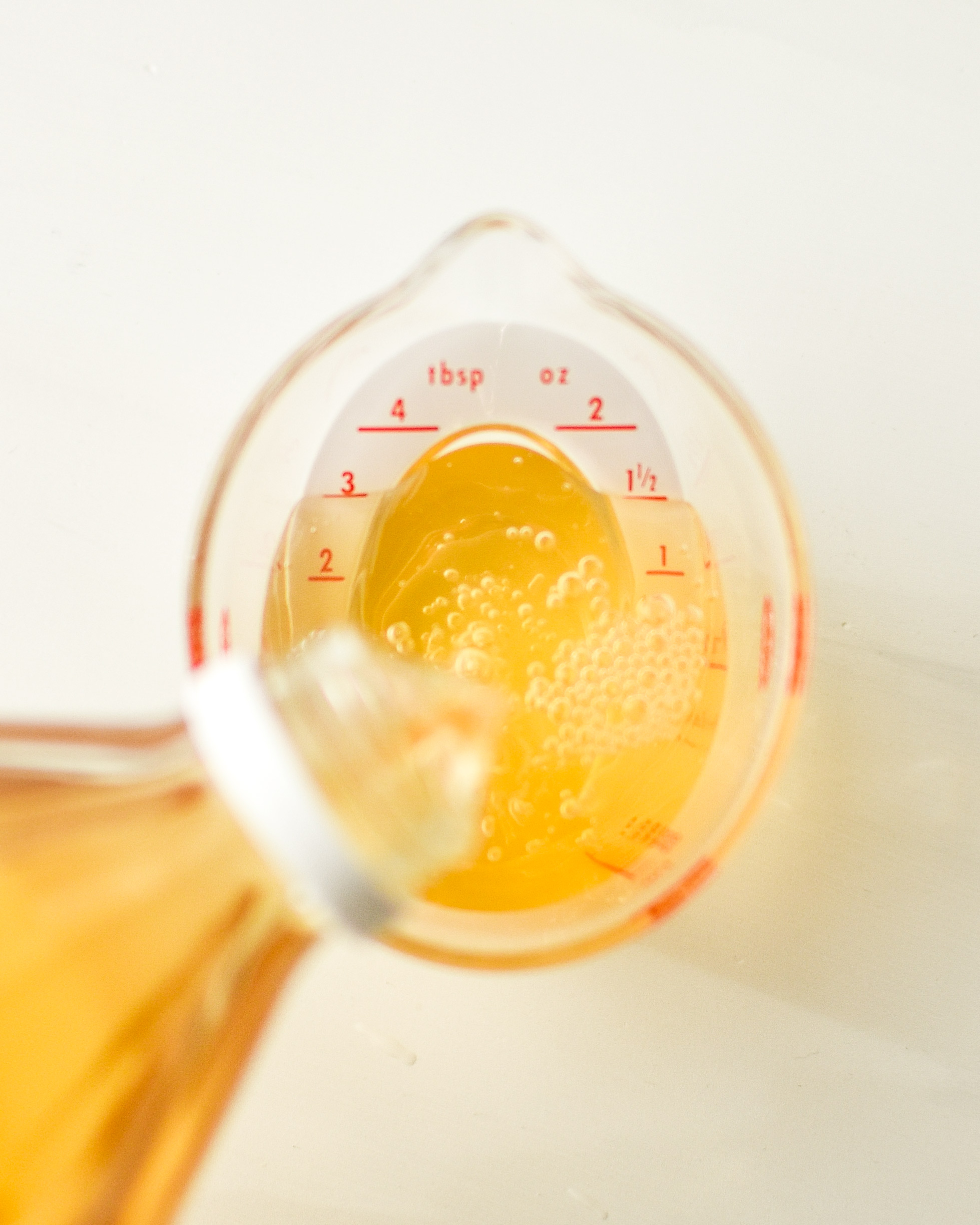 using an angled measuring cup to measure apple cider vinegar for the radicchio and roasted squash salad