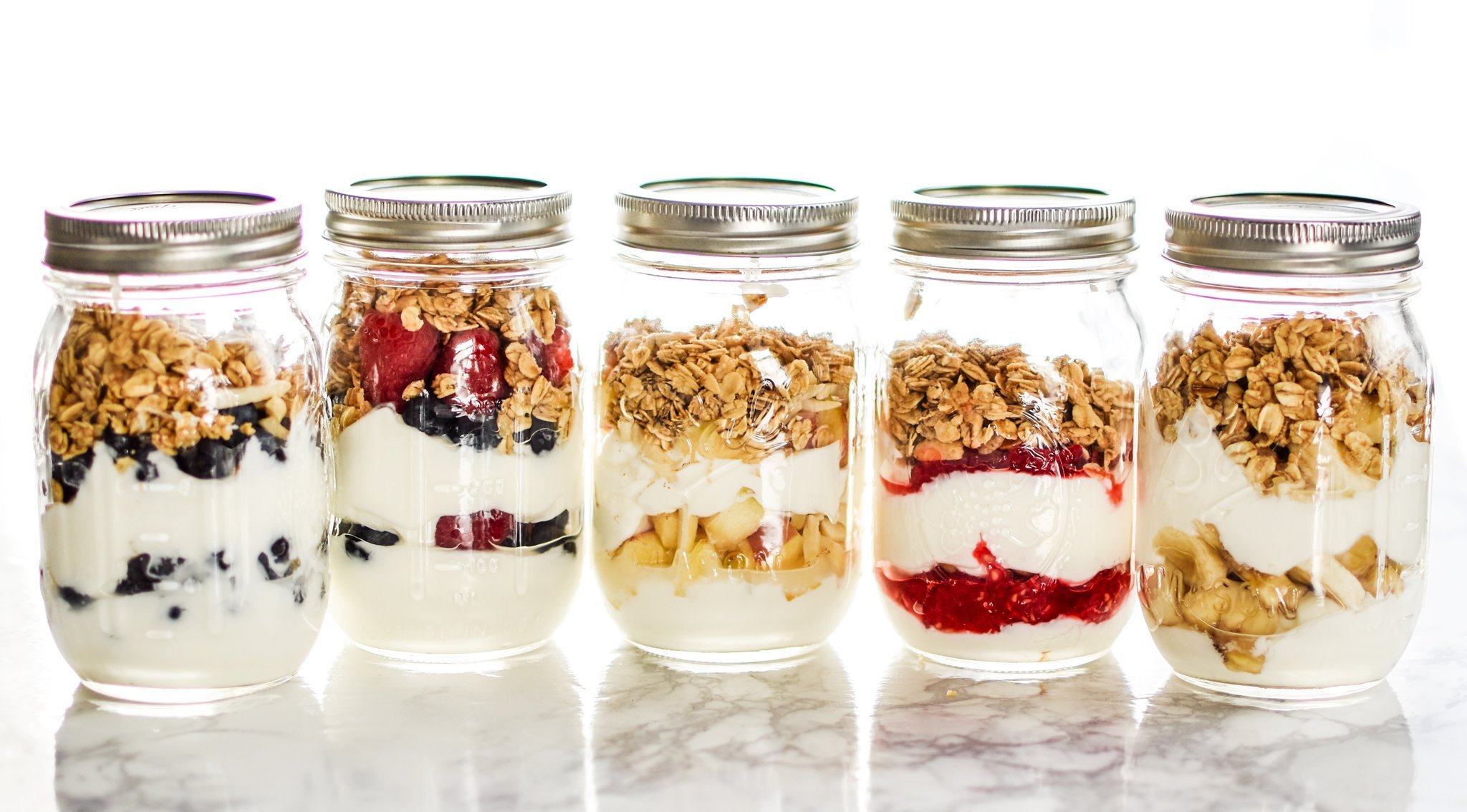 Fruit and greek yogurt parfaits in mason jars.