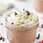 chocolate whipped greek yogurt in a small mason jar with whipped cream on top.