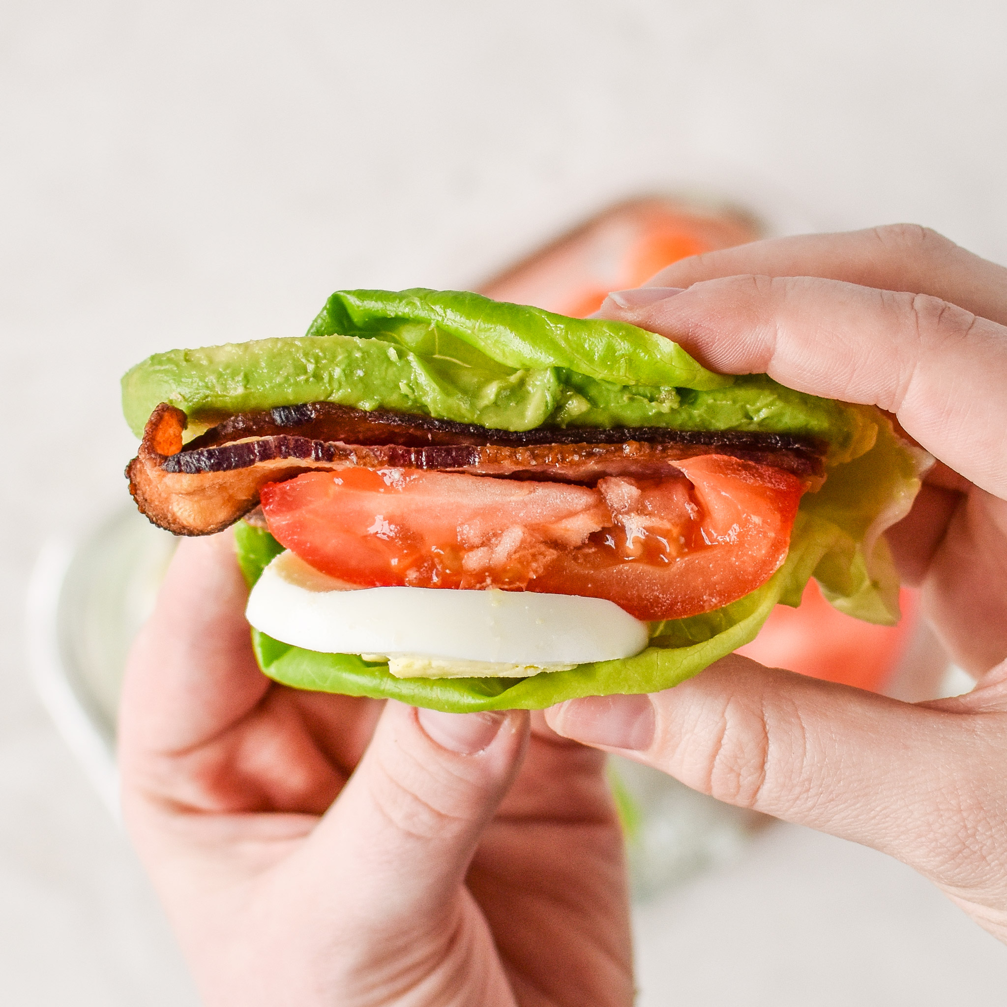 Holding a BLTA lettuce wrap in hand ready to eat.