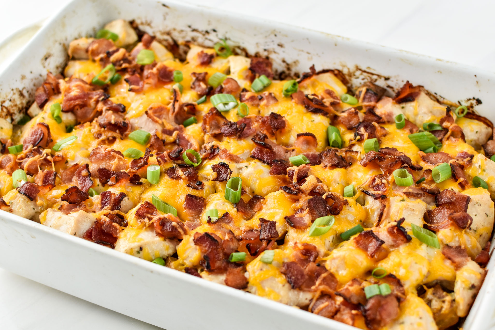 Chicken bacon ranch potato bake fresh from the oven in a rectangular dish.