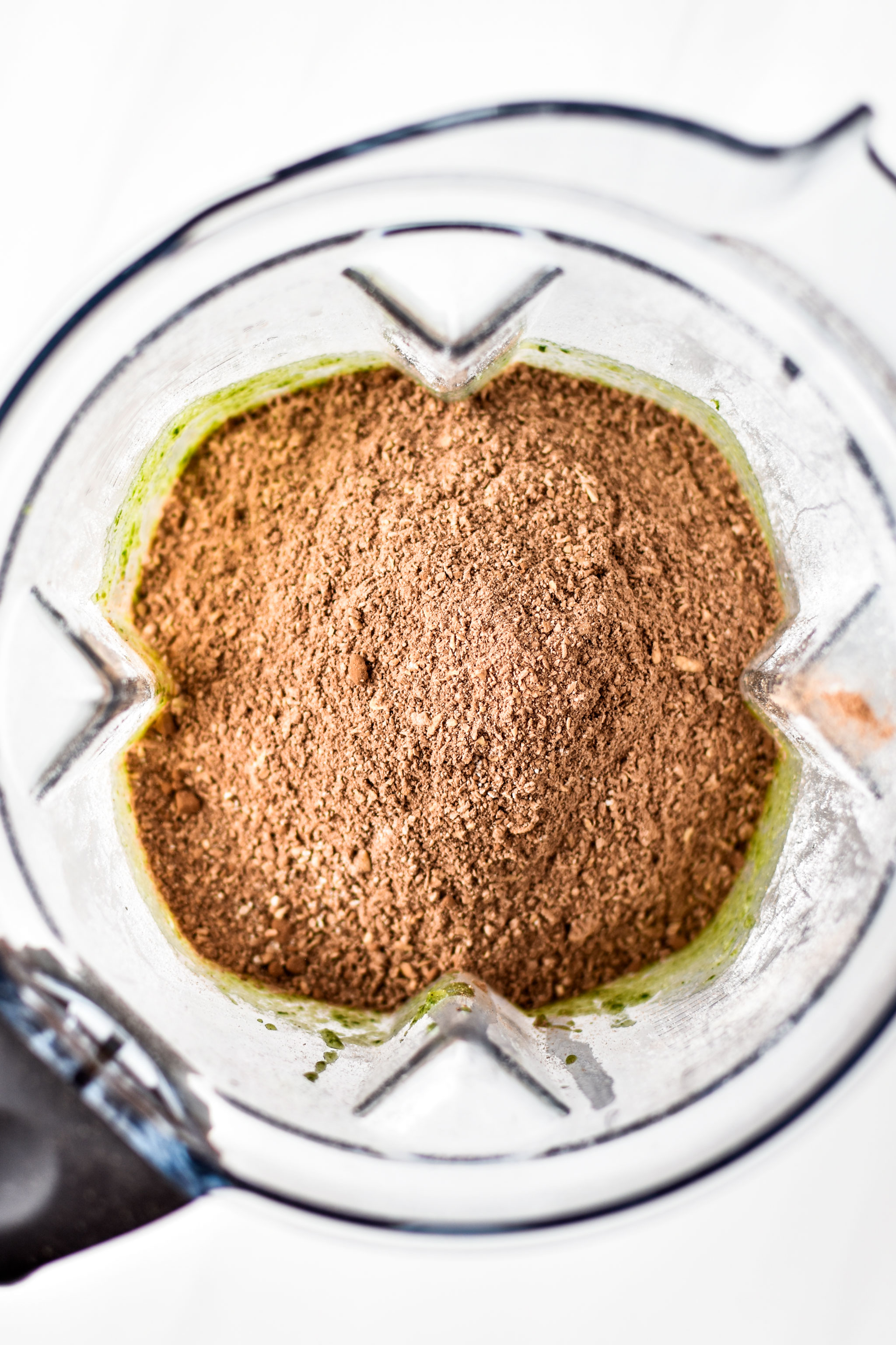 adding the oat flour mixture to the wet blended ingredients for the chocolate spinach blender muffins