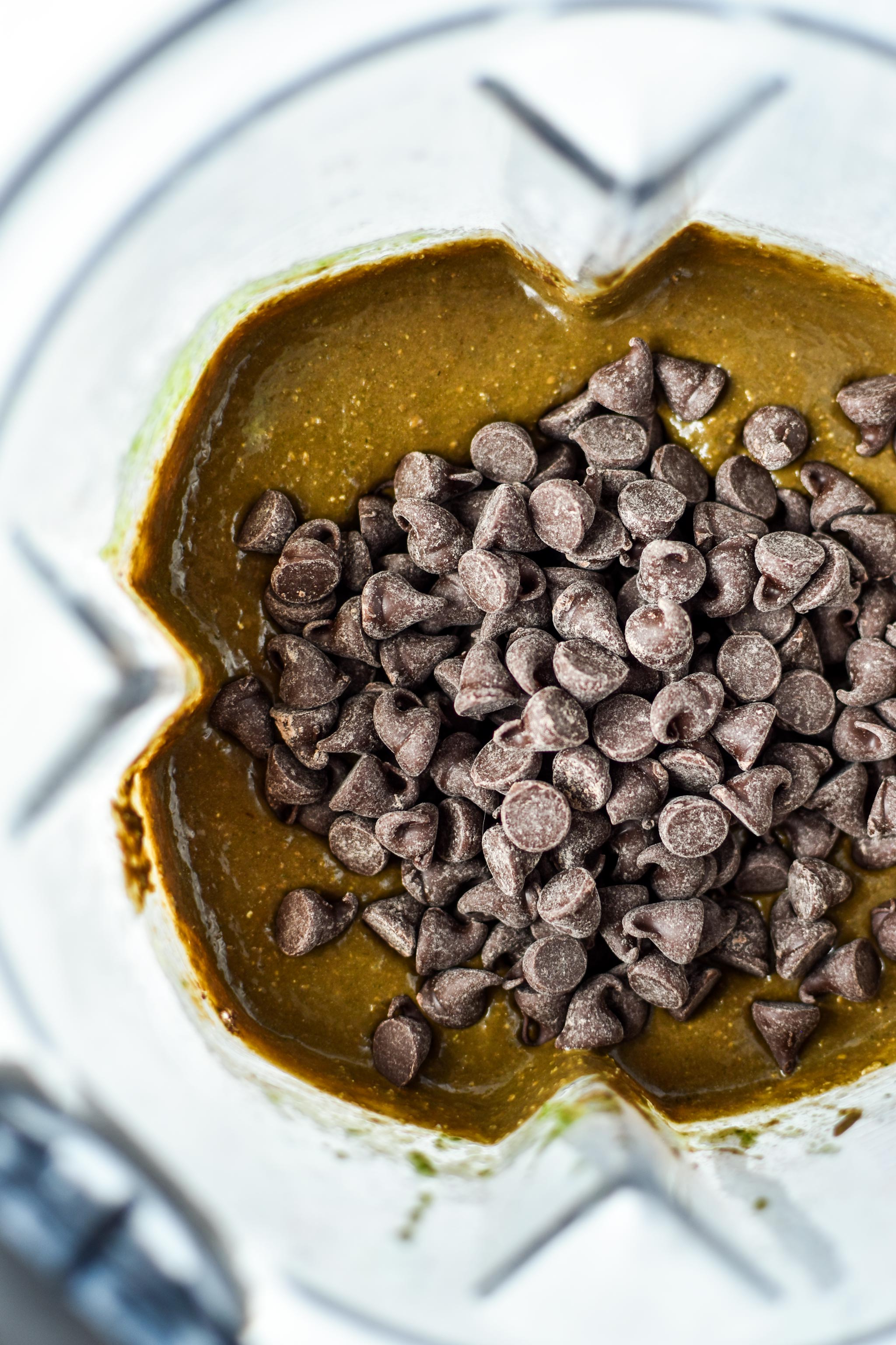 chocolate chips being mixed into the batter for the chocolate spinach blender muffins
