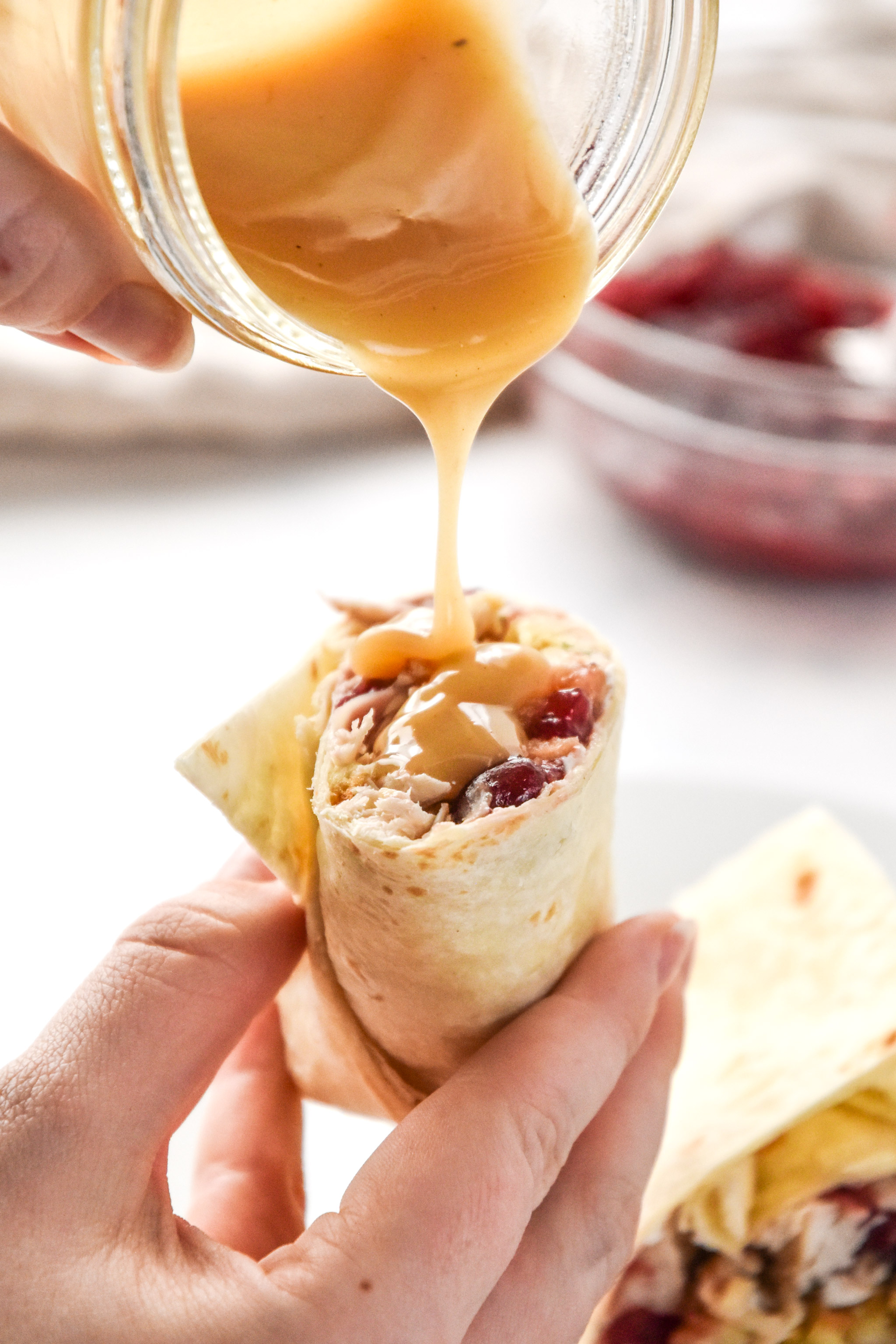 drizzling gravy over a turkey gobbler wrap