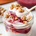 A spoonful of the cinnamon orange cranberry yogurt parfait with granola on top