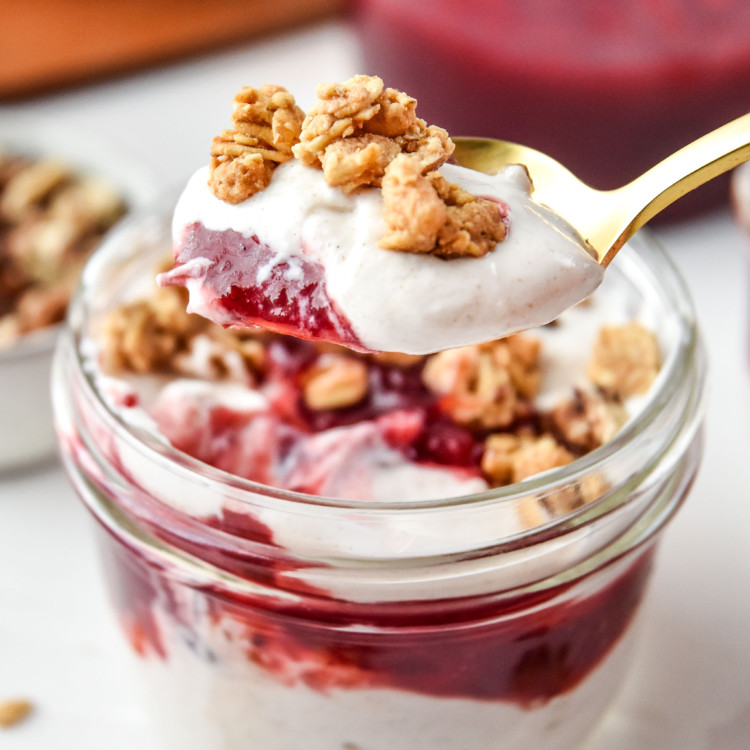 A spoonful of the cinnamon orange cranberry yogurt parfait with granola on top