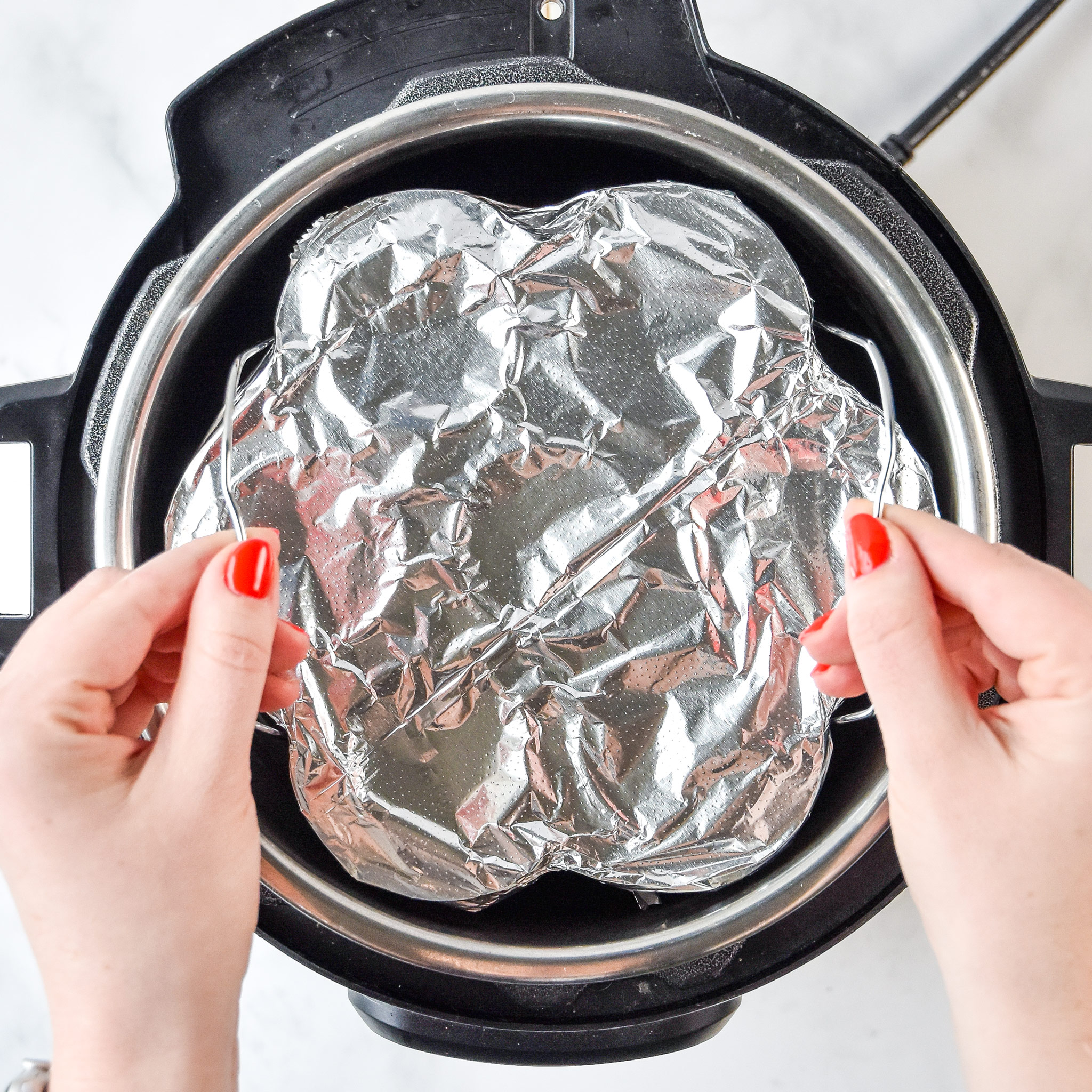 egg bites lowering into the instant pot on a trivet