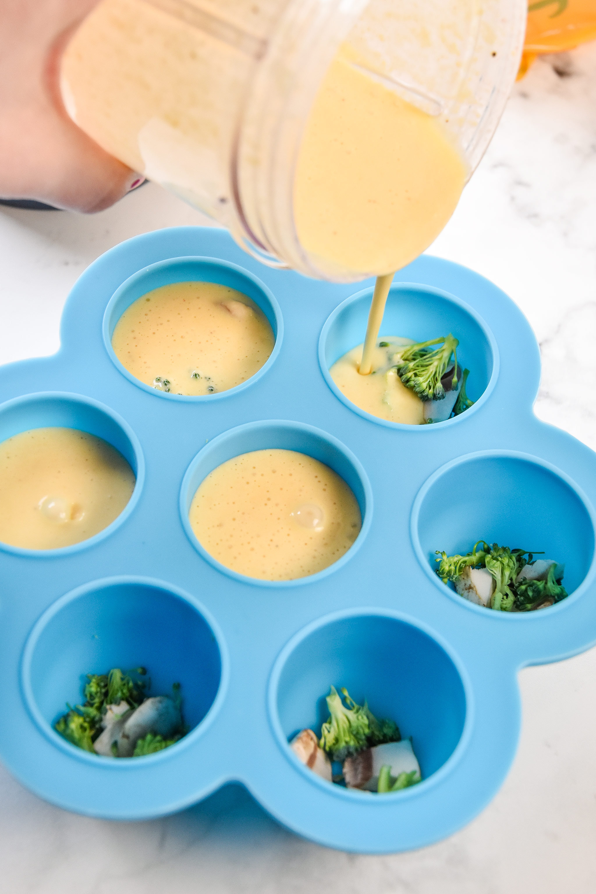 pouring egg mixture into the silicone egg bite mold
