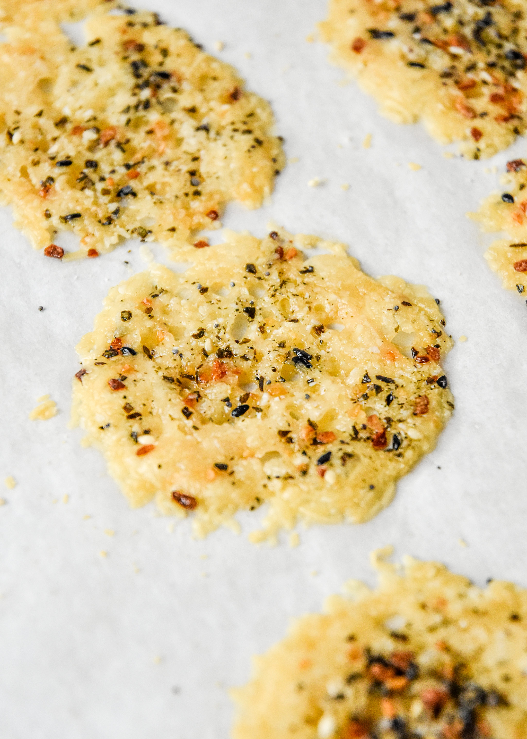 everything bagel baked parmesan cheese crisps on baking sheet close up