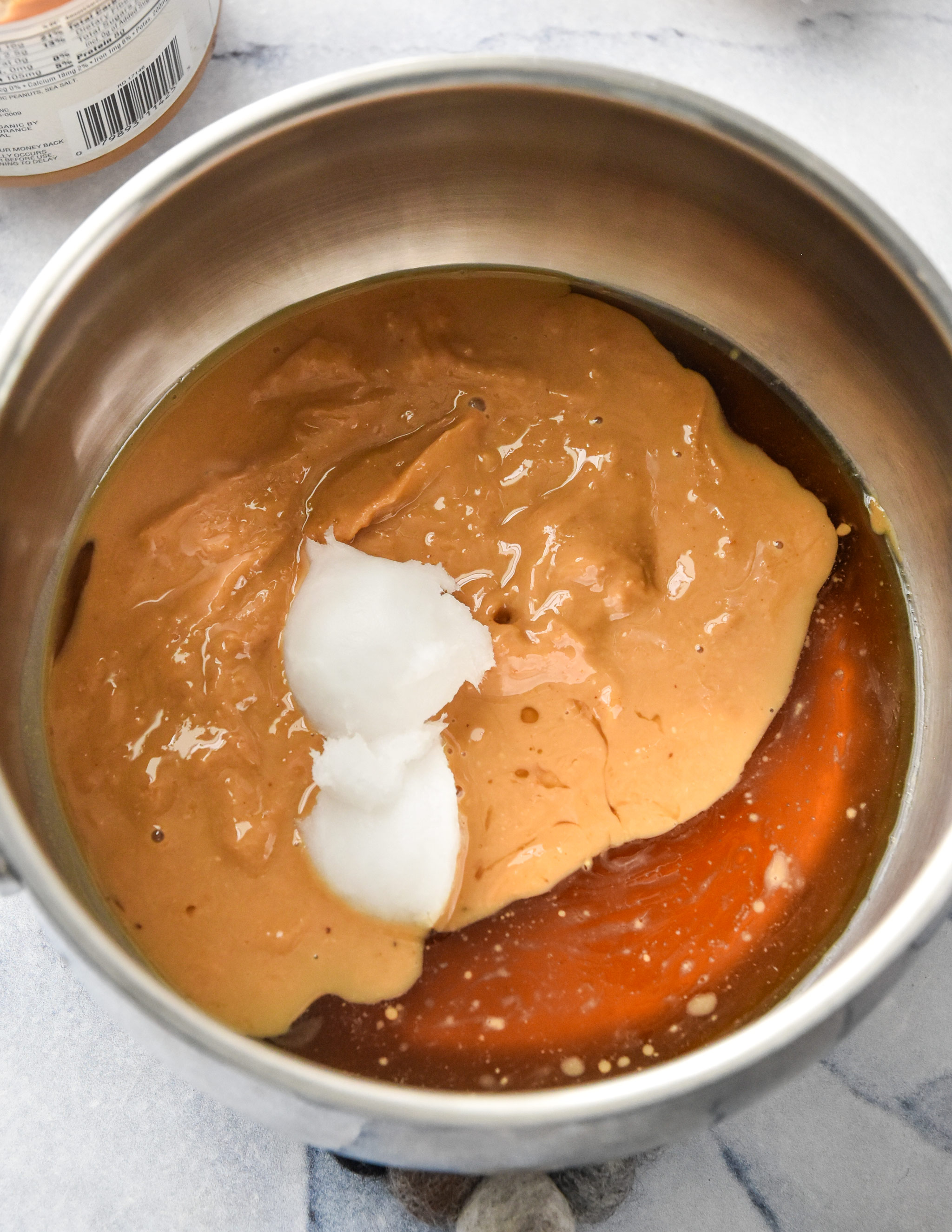 peanut butter, maple syrup and coconut oil in a pot for the rice krispie breakfast bars
