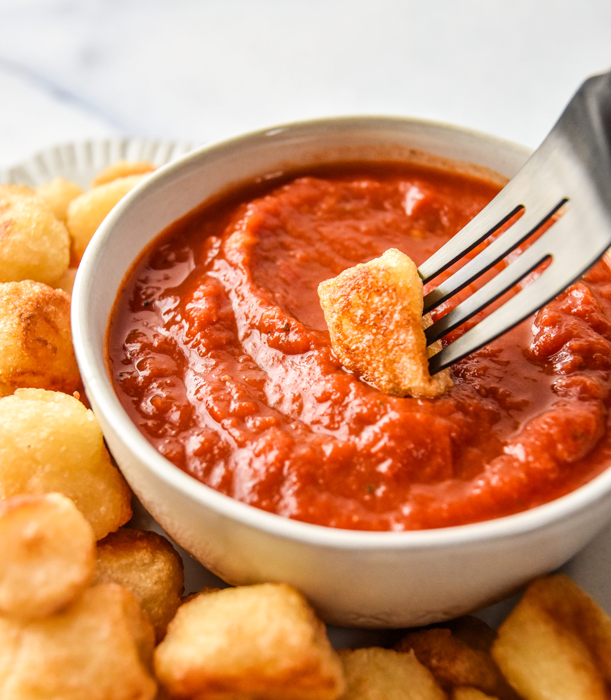 dipping air fryer cauliflower gnocchi in marinara sauce