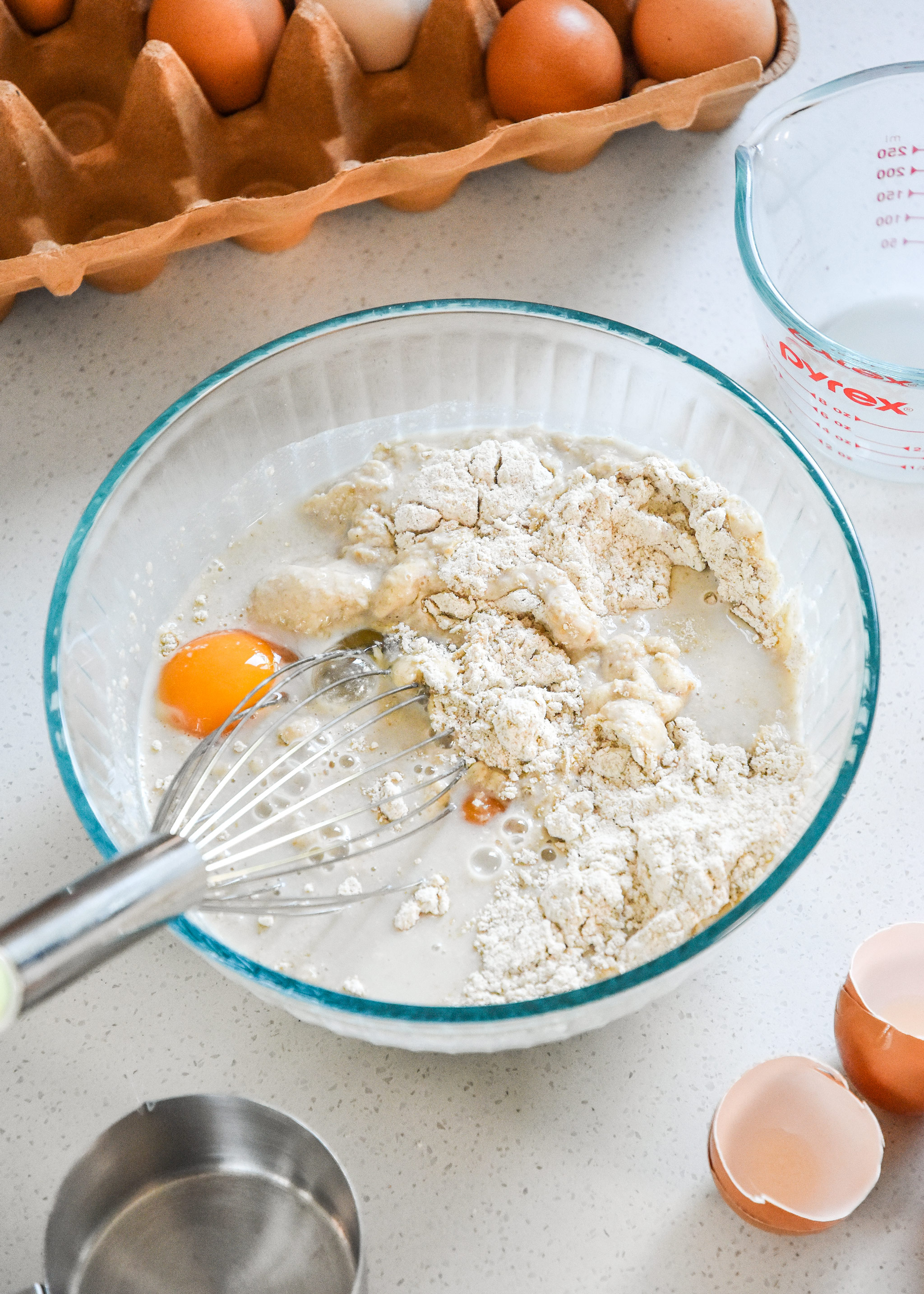 mixing pancake batter with eggs and milk in a bowl