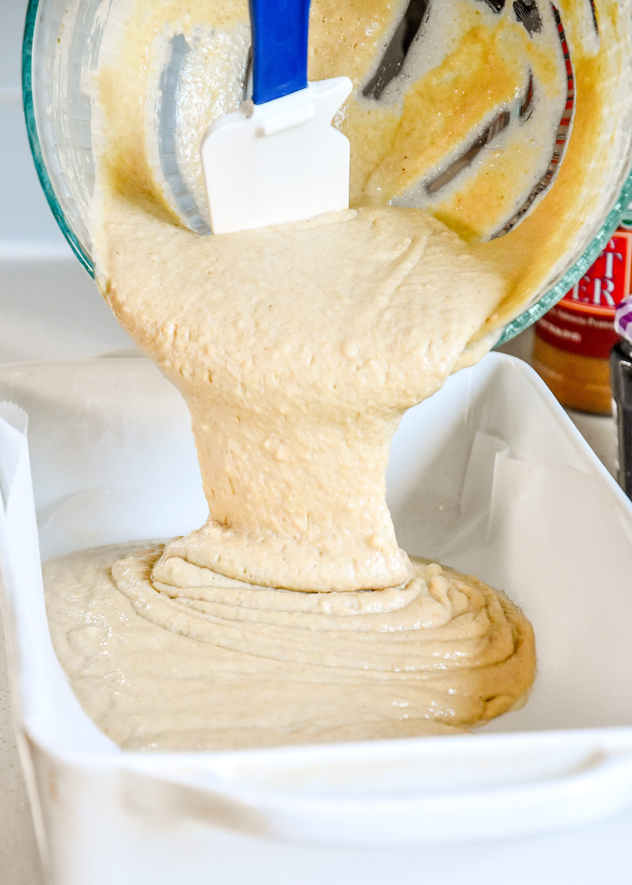 pouring pancake batter into the prepared casserole dish