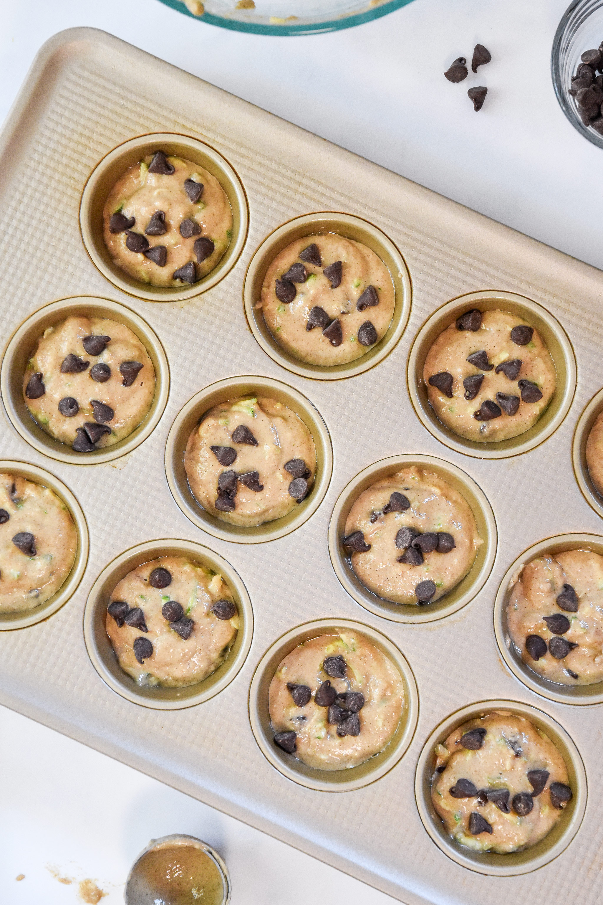batter in a muffin tin for the pancake mix zucchini muffins.