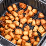 homemade croutons in an air fryer basket.