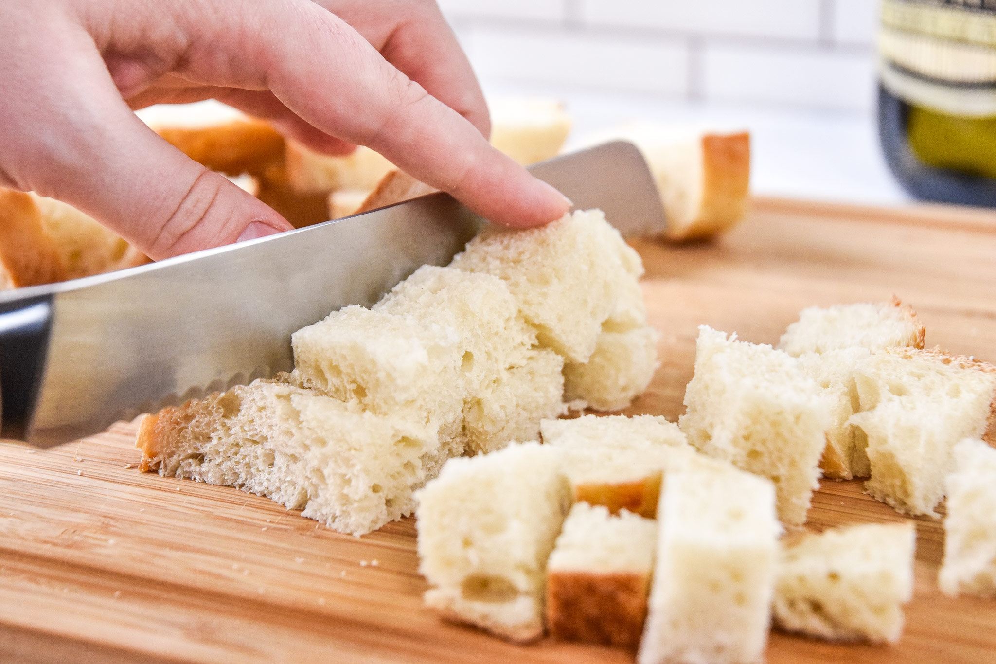 cutting sourdough bread into cubes for cruotons.