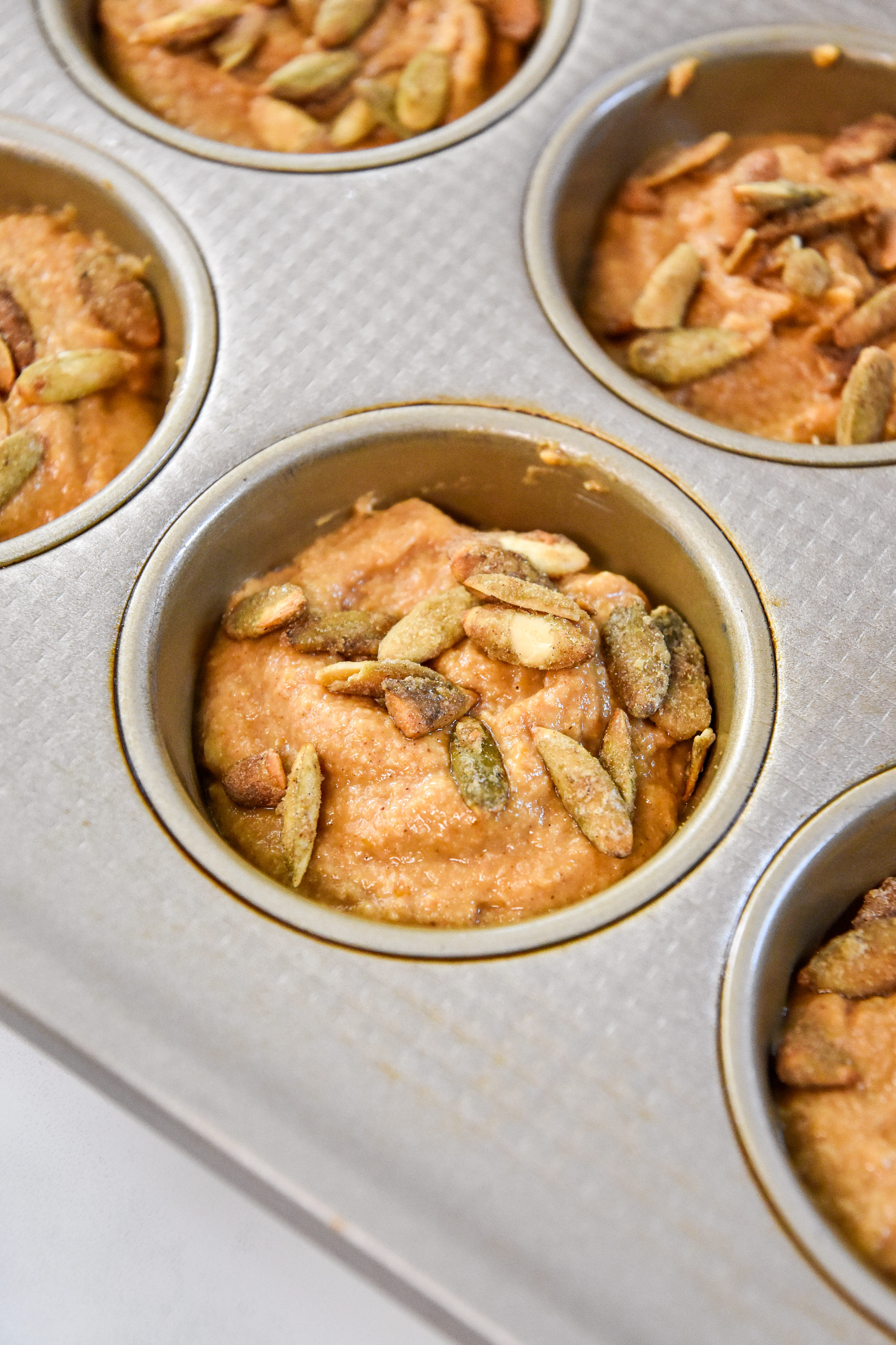 batter in the muffin tin before baking the pancake mix muffins.