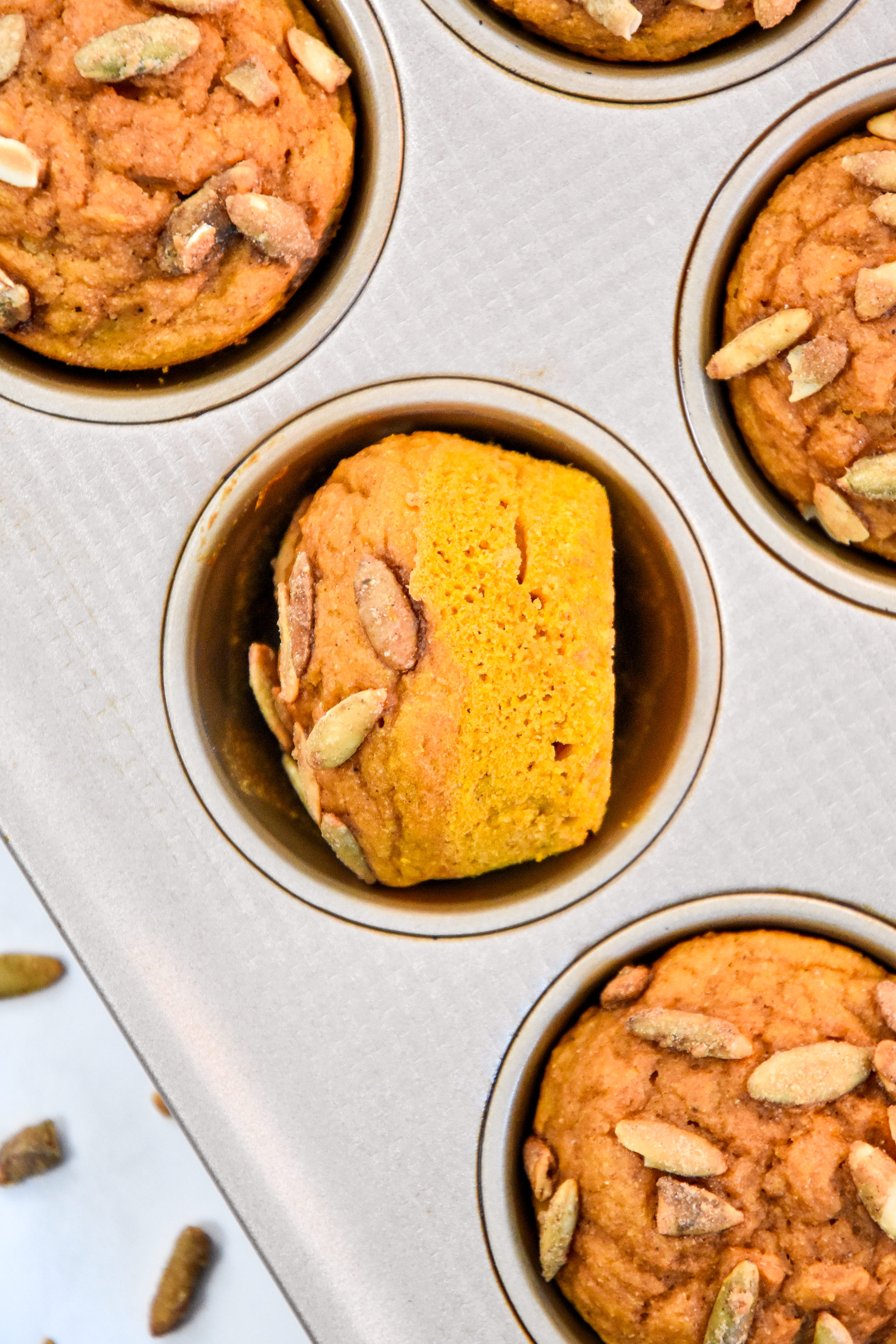 close up of a pumpkin spice pancake mix muffin fresh baked turned sideways in the muffin tin.