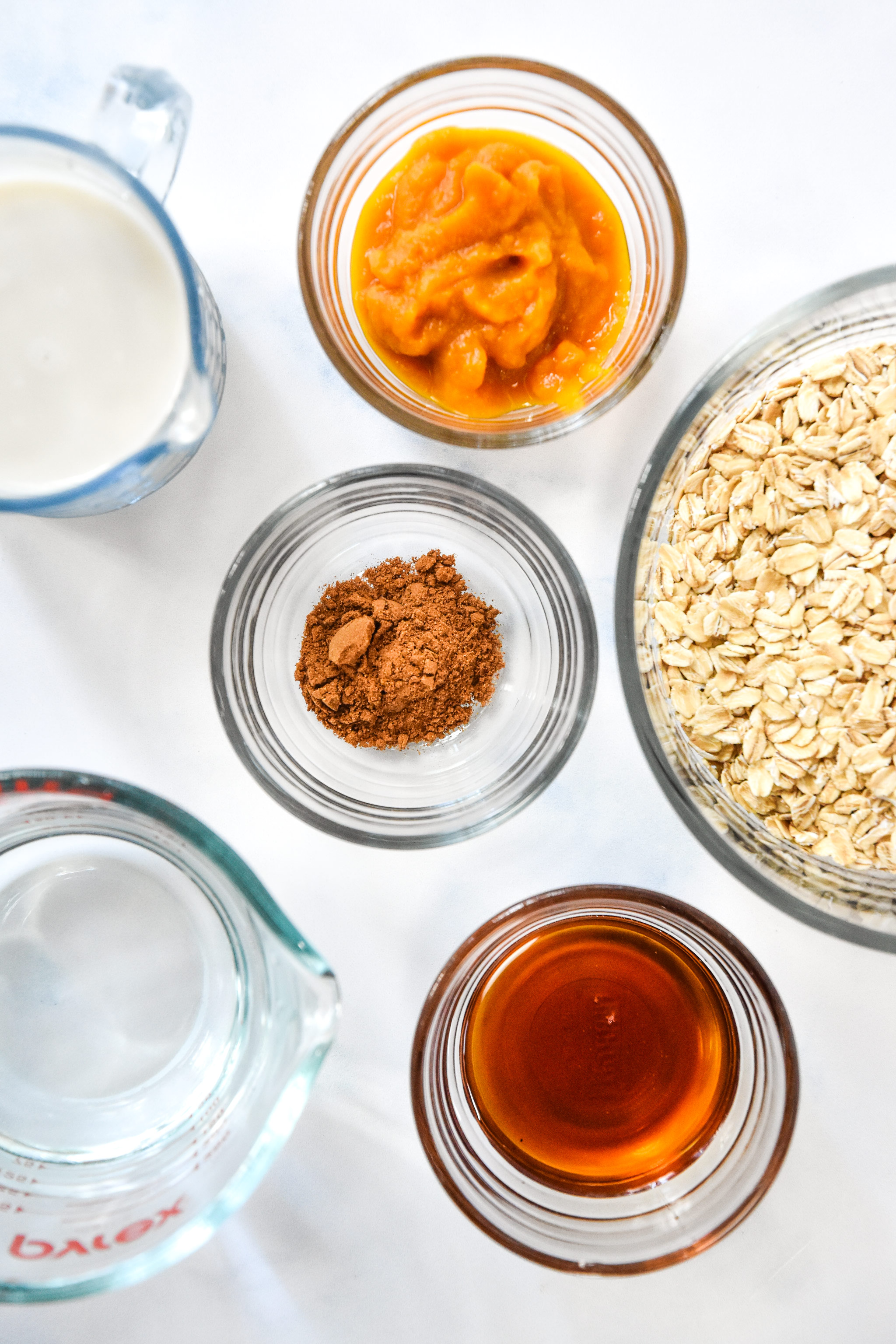 ingredients for the oatmeal including oats, pumpkin puree, and maple syrup.