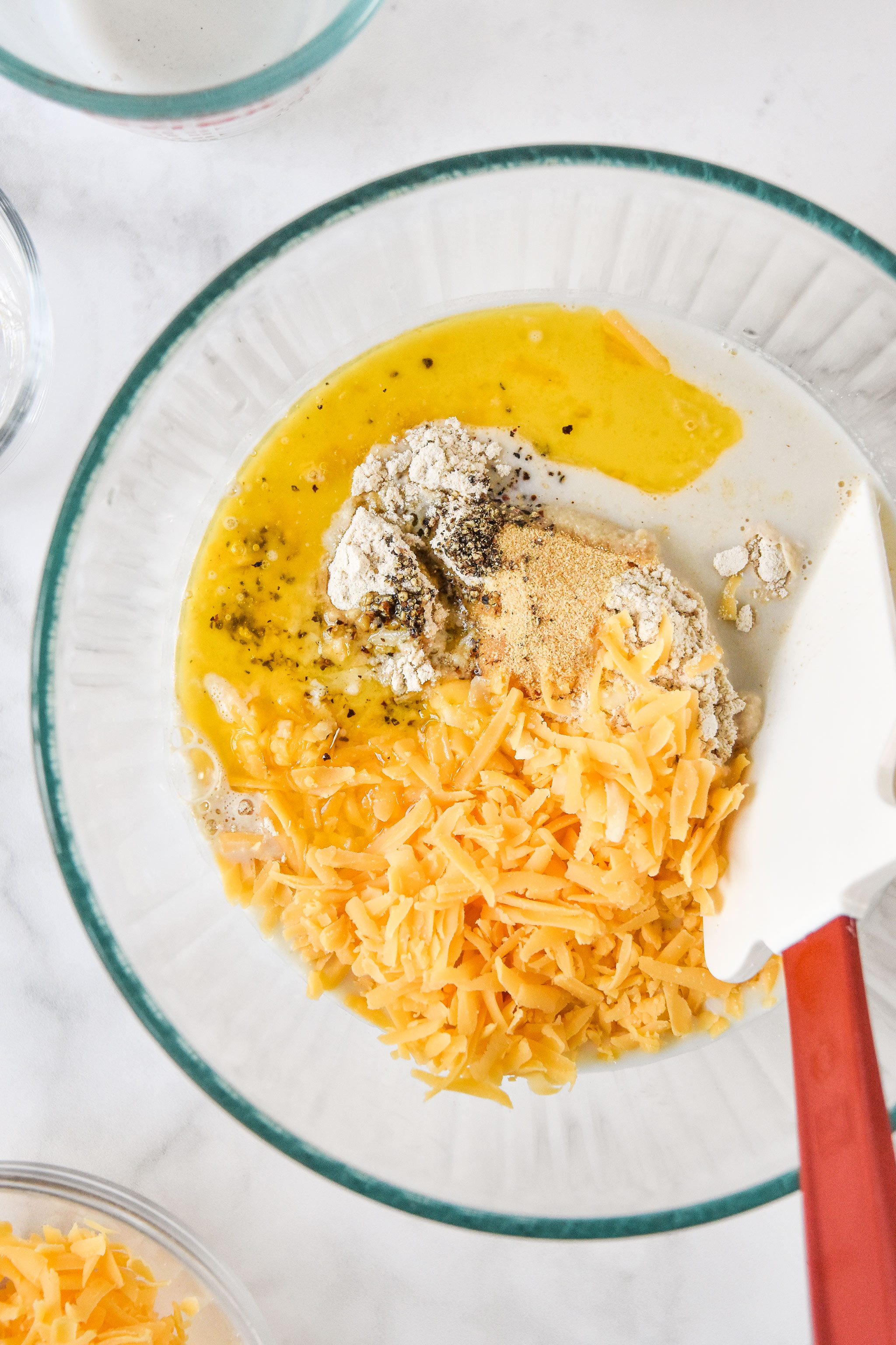 ingredients for pancake mix cheddar drop biscuits in a glass bowl.