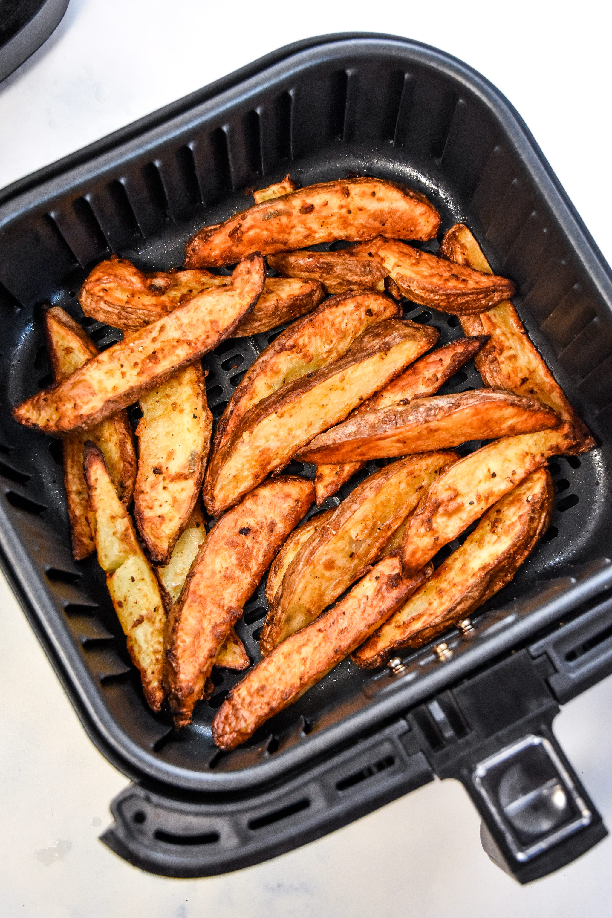 air fryer jojo potato wedges cooked in the air fryer basket.