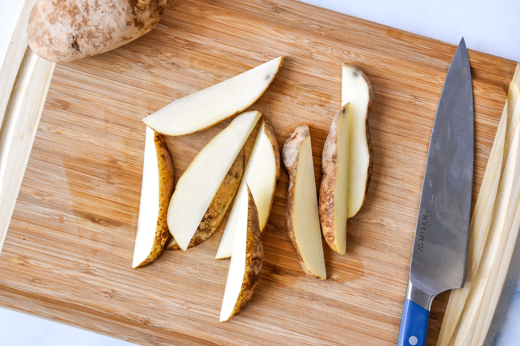 potato wedges cut on a cutting board.