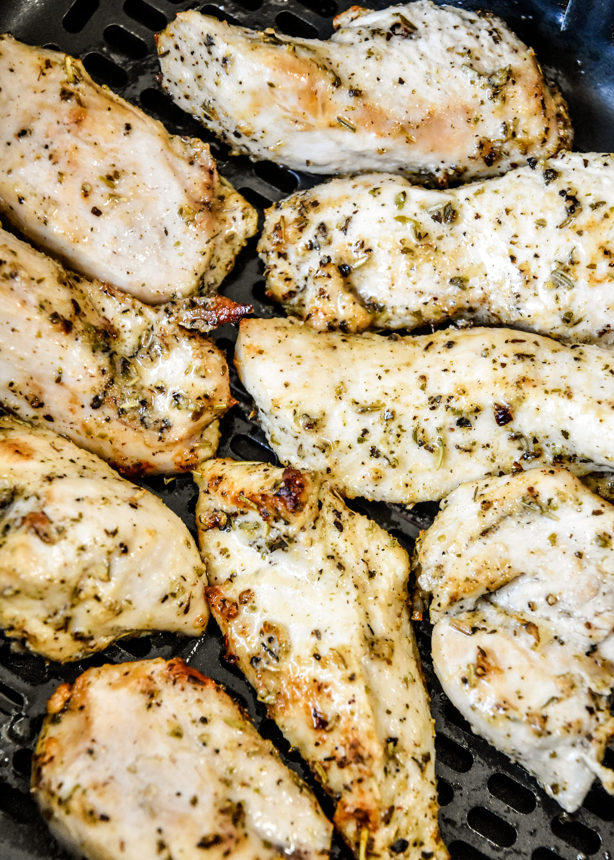 close up of the cooked chicken tenders in the air fryer basket.