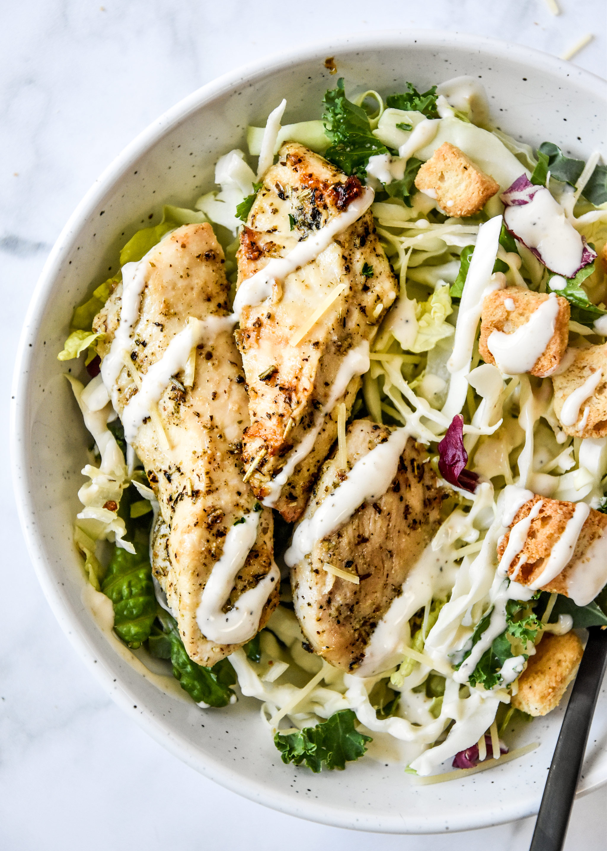 air fryer chicken tenders on a caesar salad.