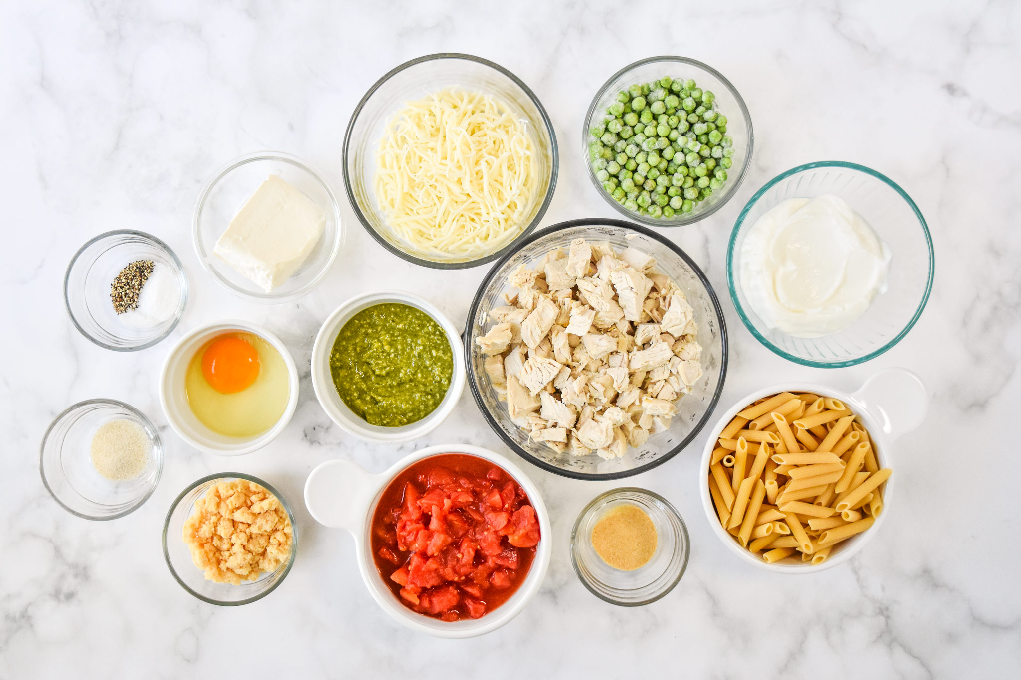 ingredients in bowls ready to make the creamy pesto pasta chicken bake.