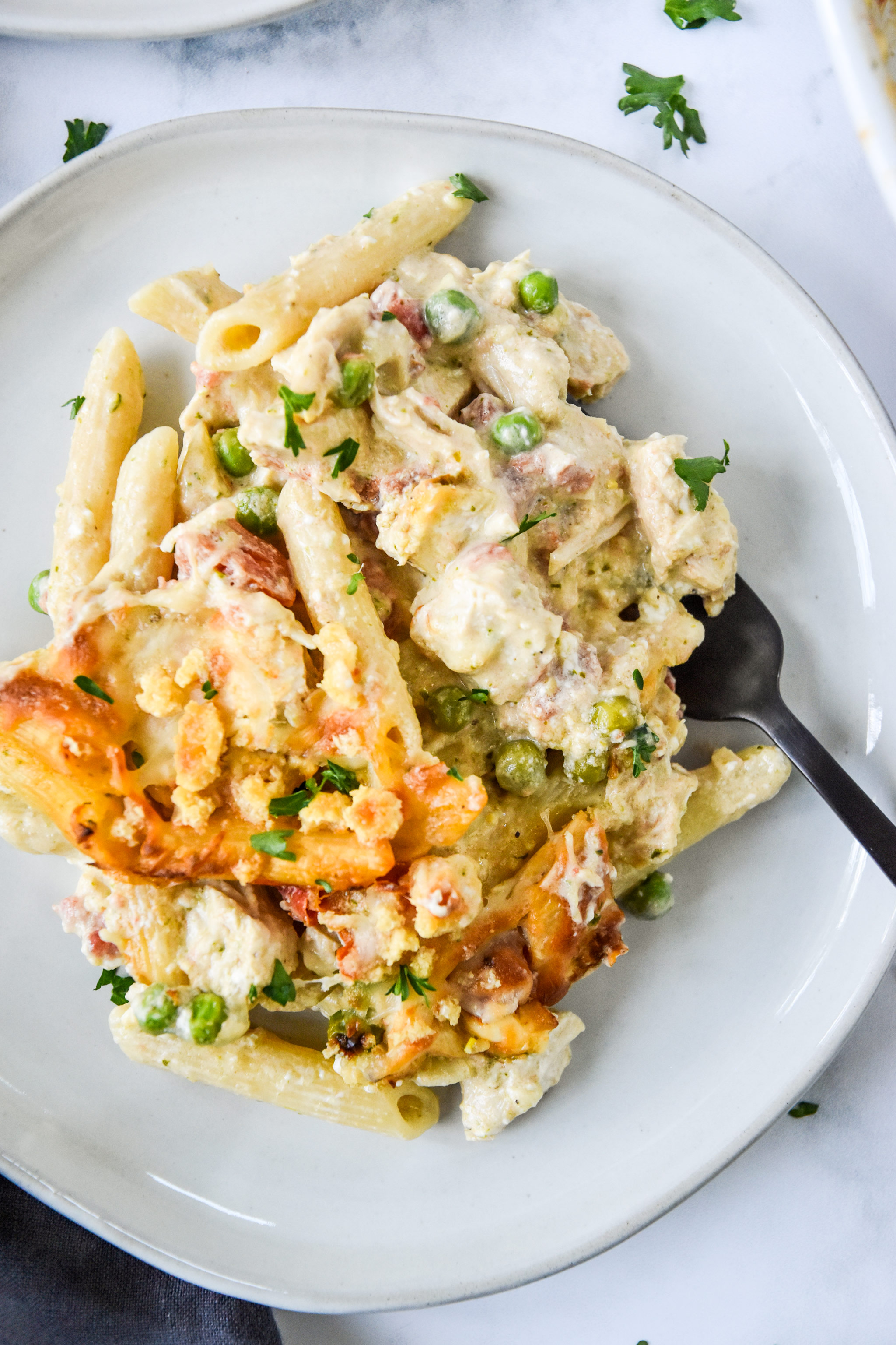 plate of pesto pasta chicken bake with a fork.