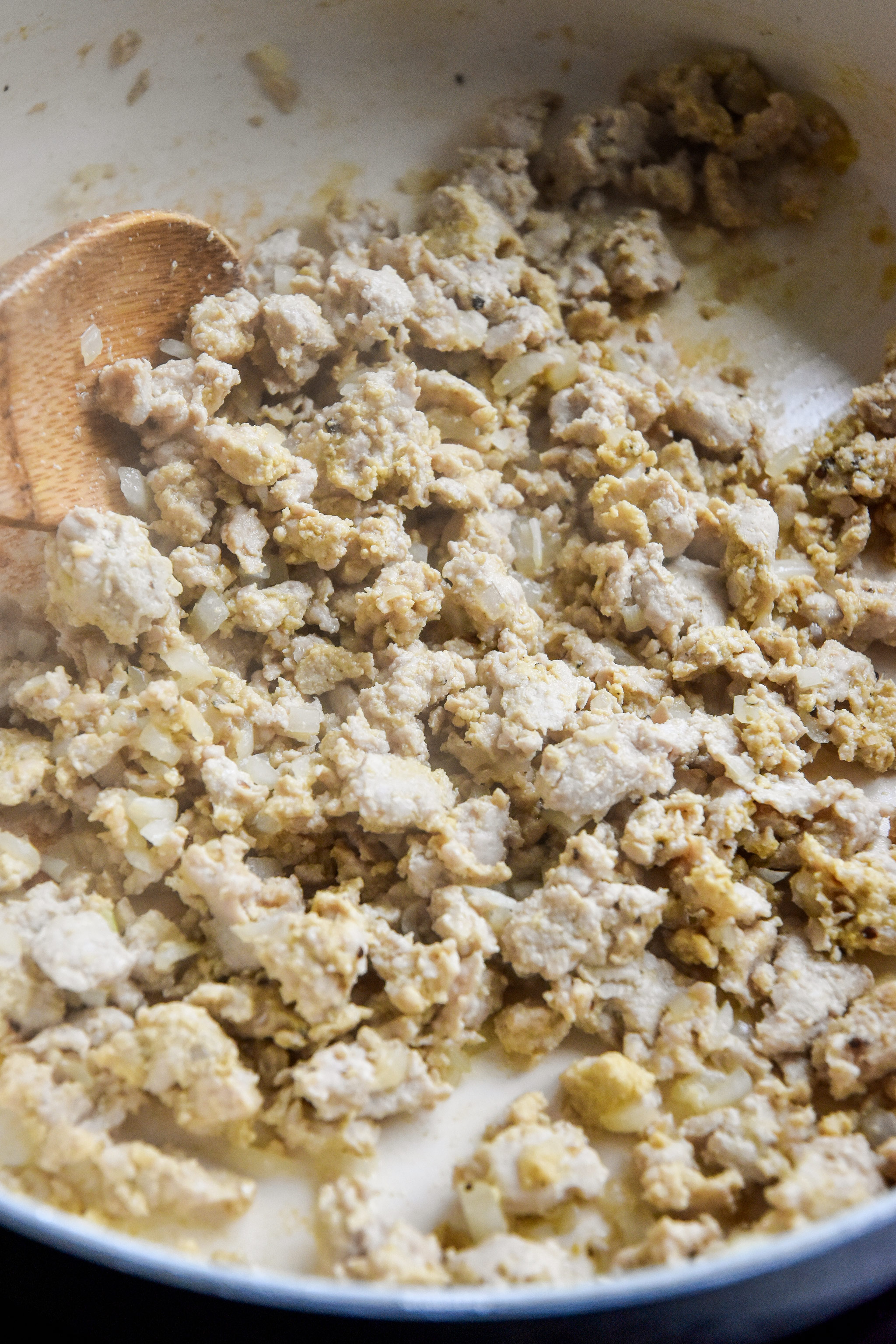 cooked ground turkey mustard mixture with a wooden spoon.