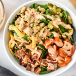 ground turkey burger salad with bacon cheese pickles, serve in a white bowl with special sauce dressing.