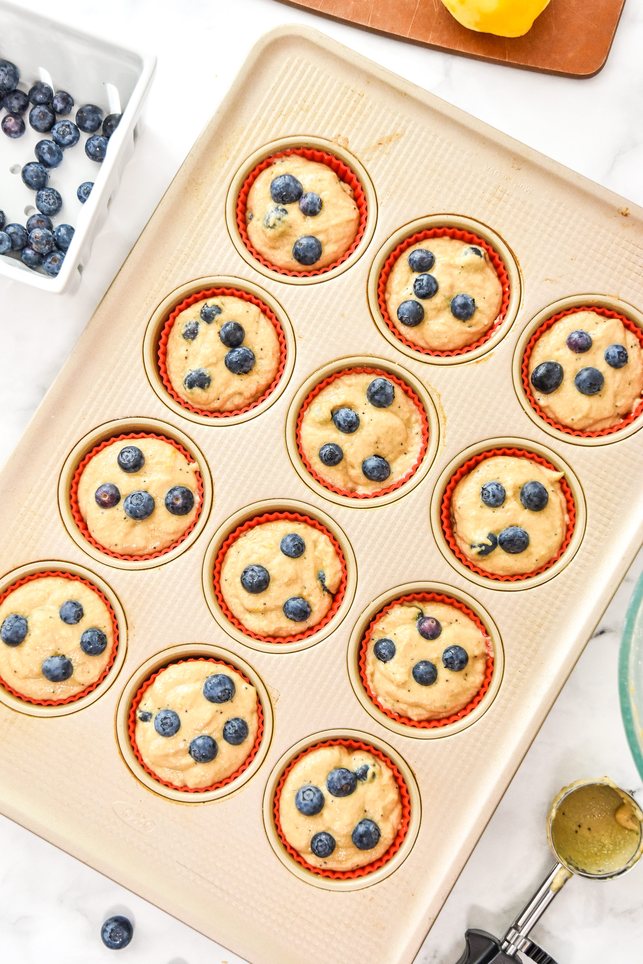 blueberry lemon pancake mix muffin batter in the muffin tin before baking.
