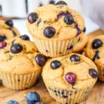 stacked muffins on a cutting board.