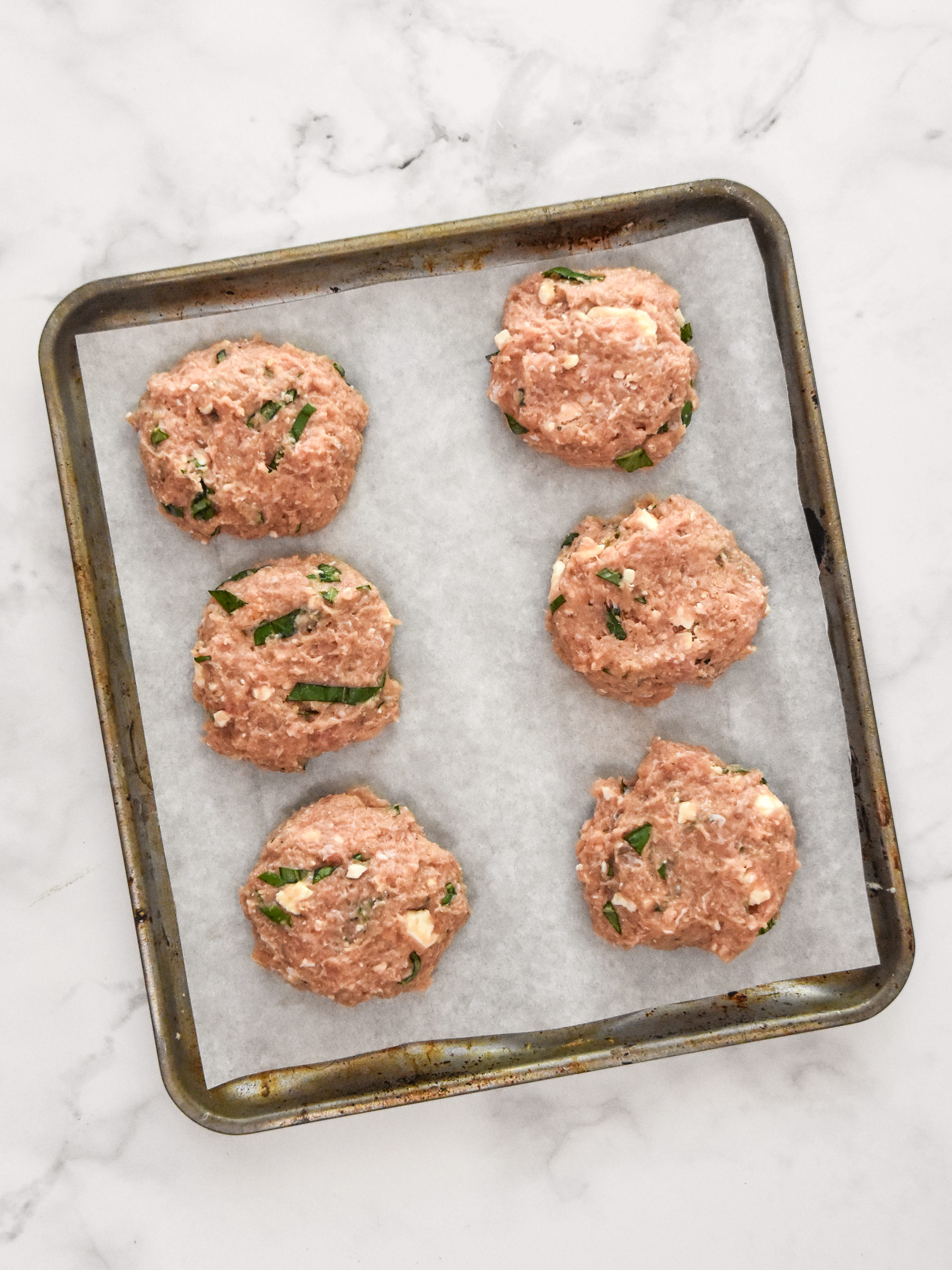 six feta basil turkey burger patties uncooked.