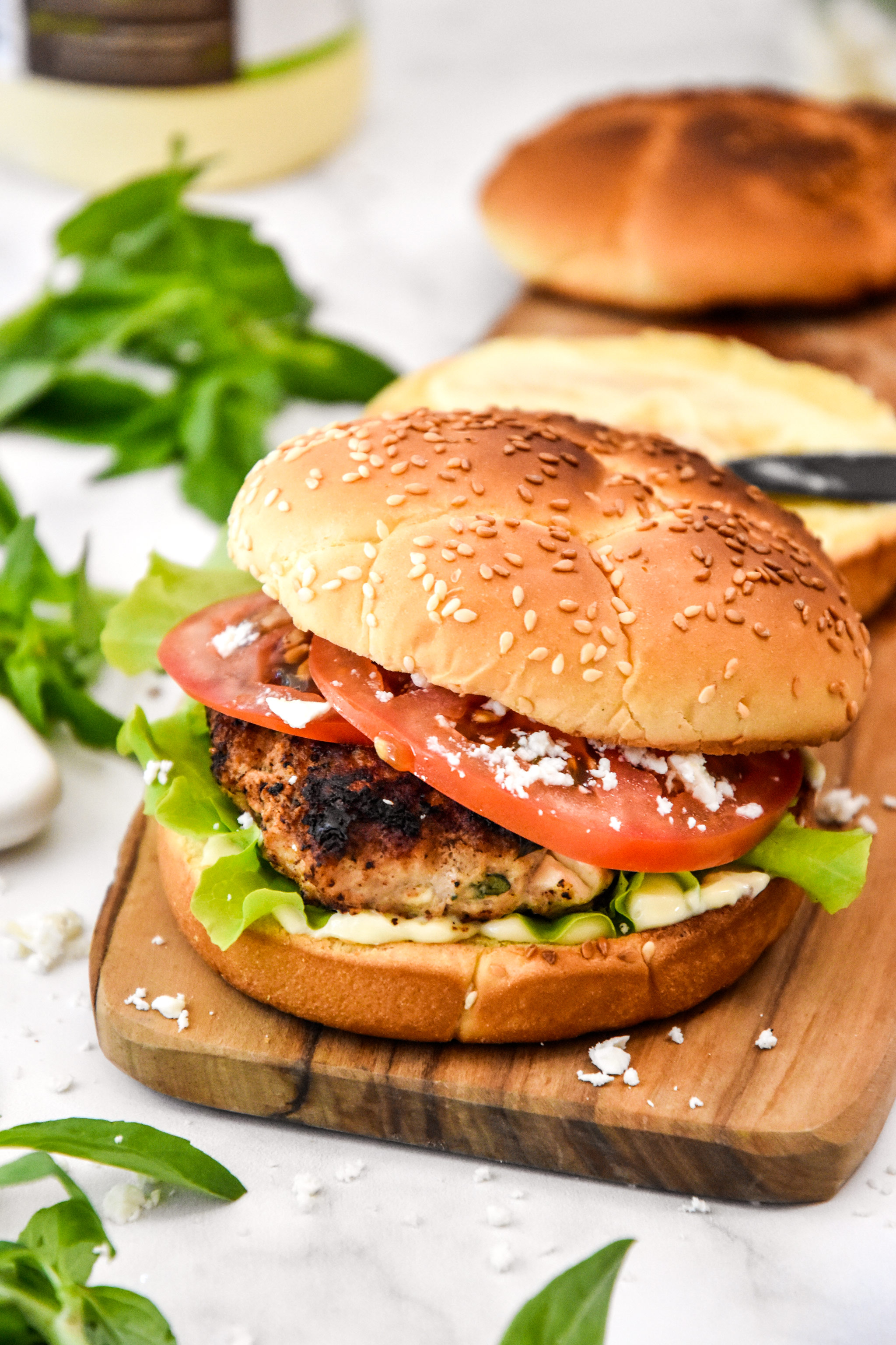 assembled feta basil turkey burger on a cutting board.