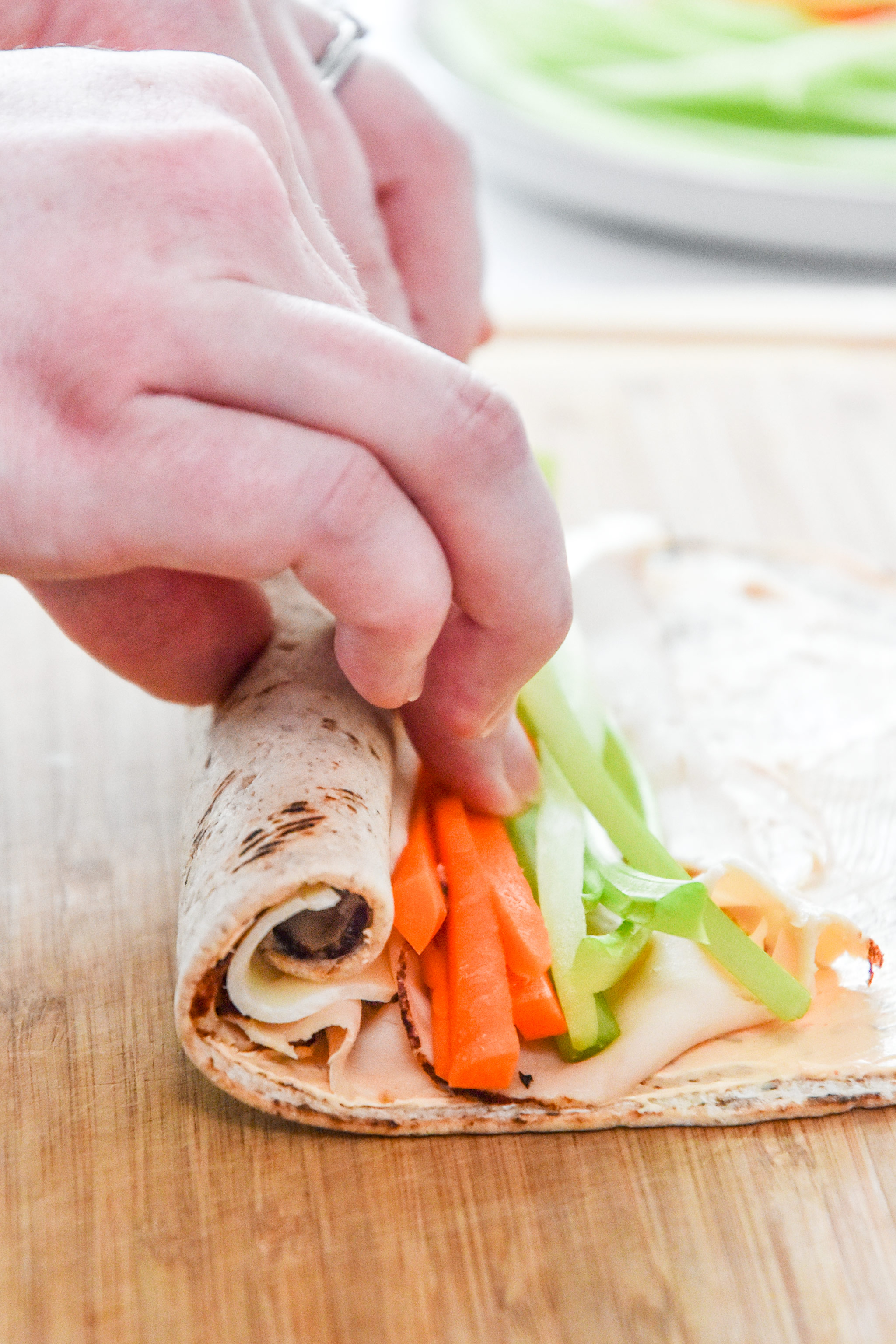 view of rolling the buffalo chicken pinwheels from the side.
