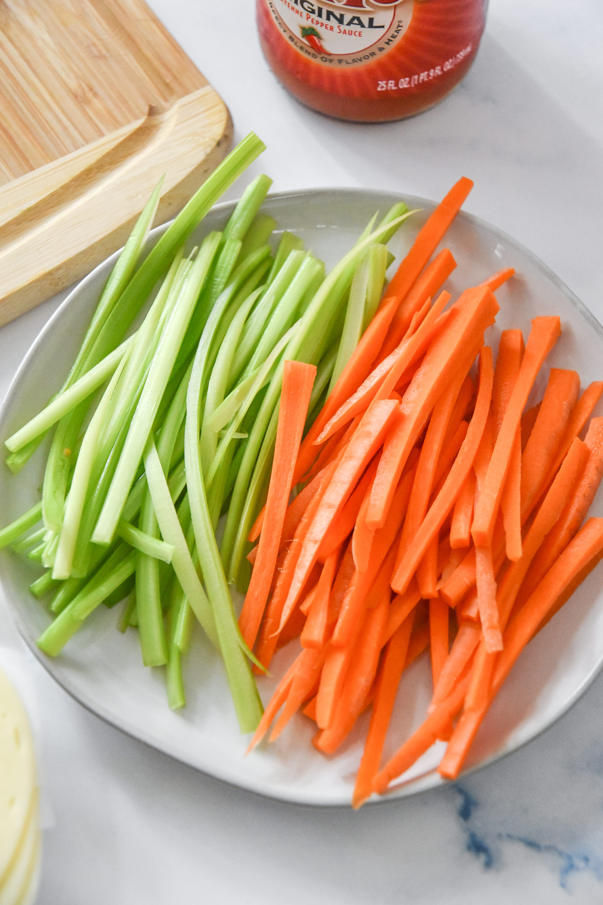 julienned carrots and celery on a plate.