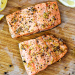 air fryer lemon pepper salmon filets on a cutting board.